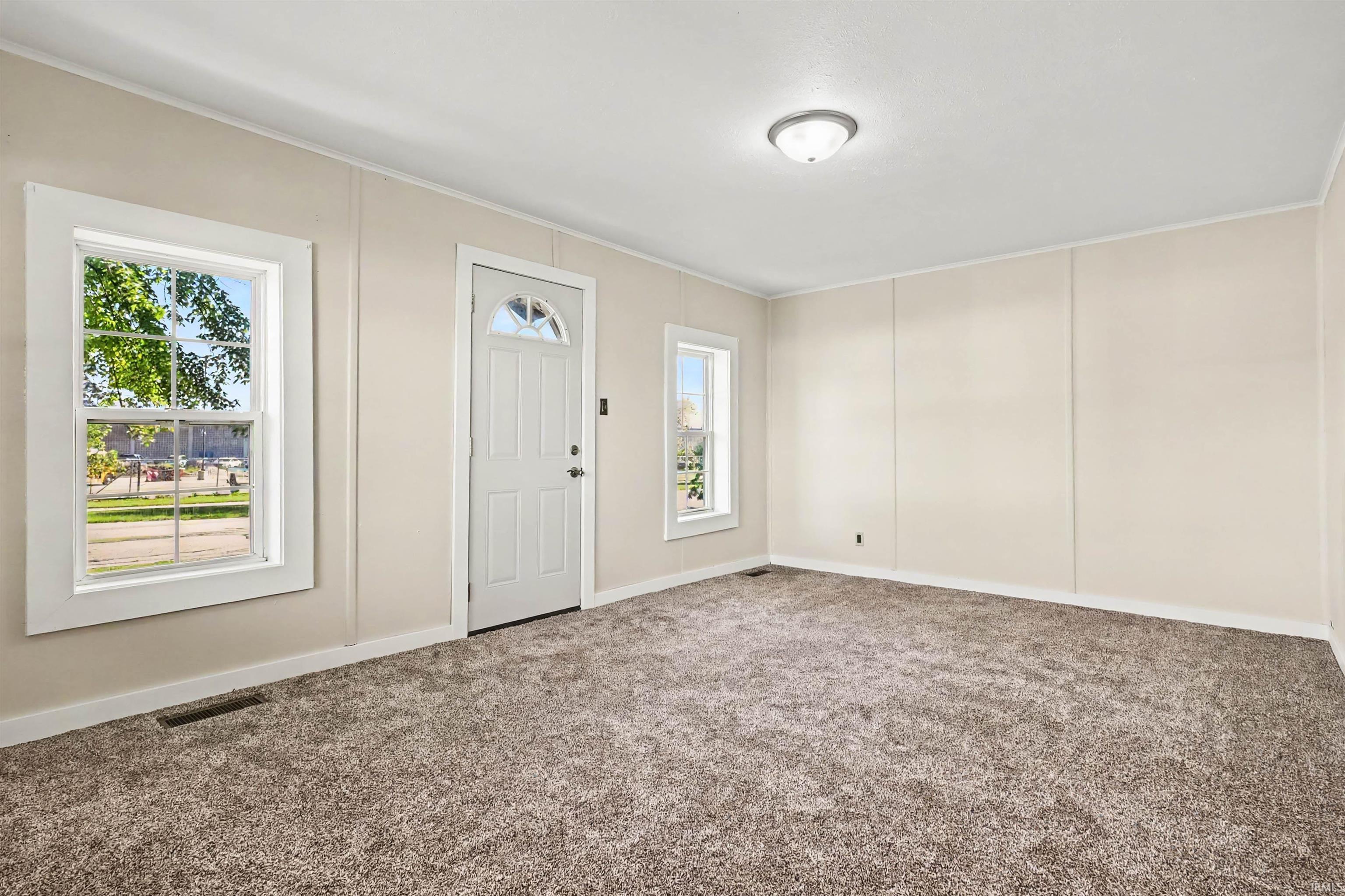 Neutral-toned walls complement the textured gray carpeting