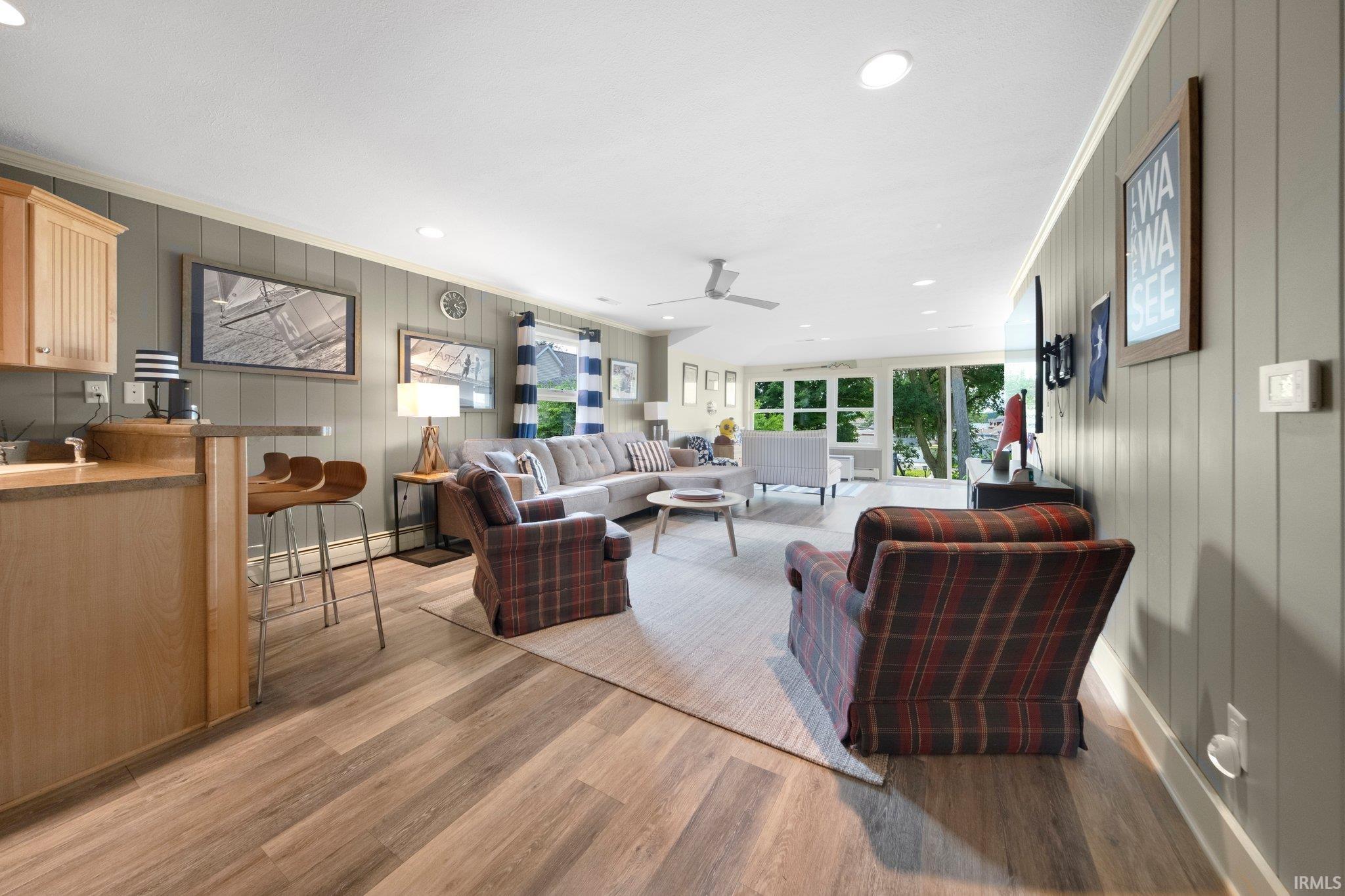Open-concept living area featuring wood-finish flooring, recessed lighting, and board-and-batten wall paneling