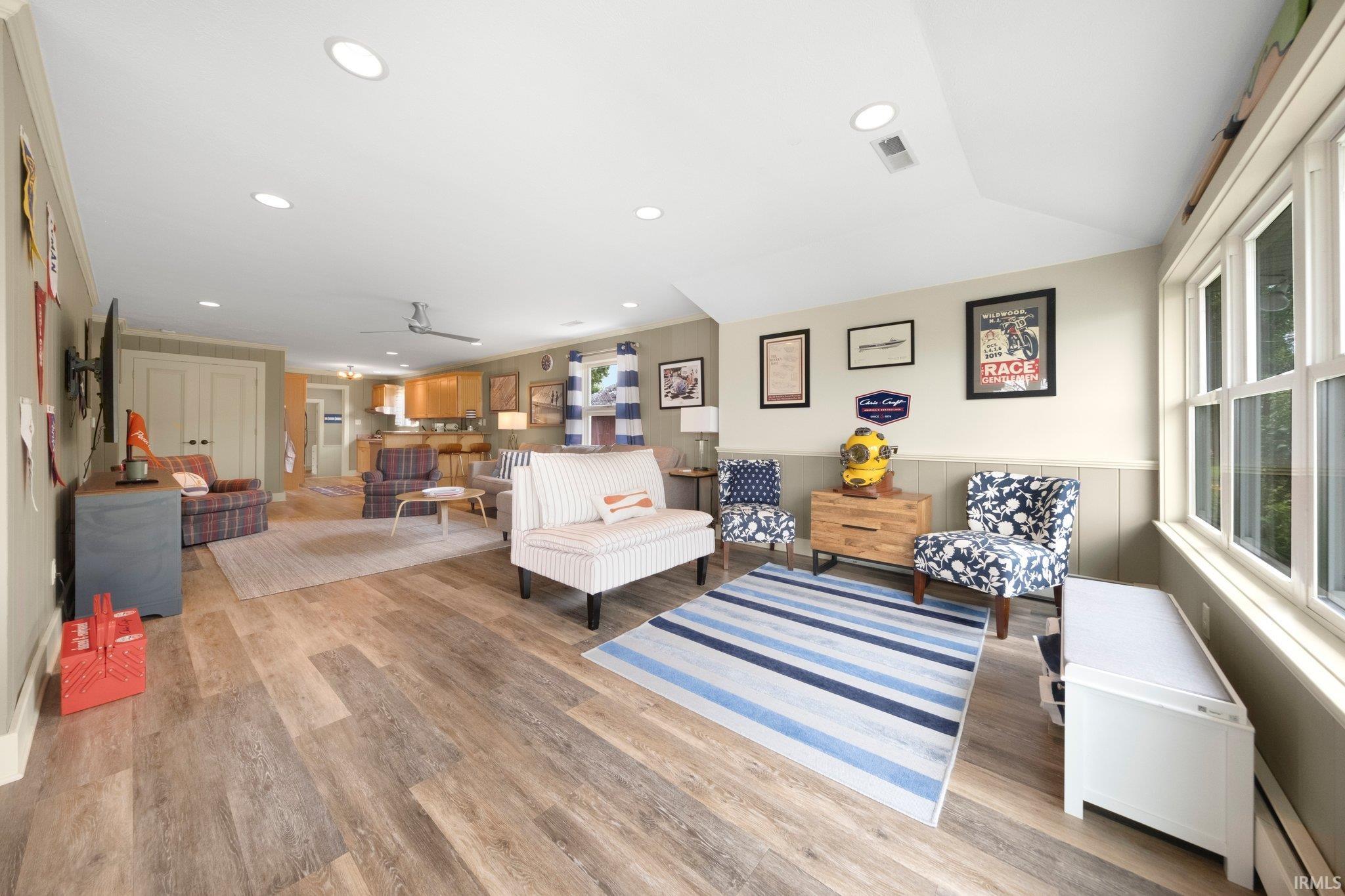 Spacious room featuring wood-finish flooring, recessed lighting, and ample natural light from multiple windows