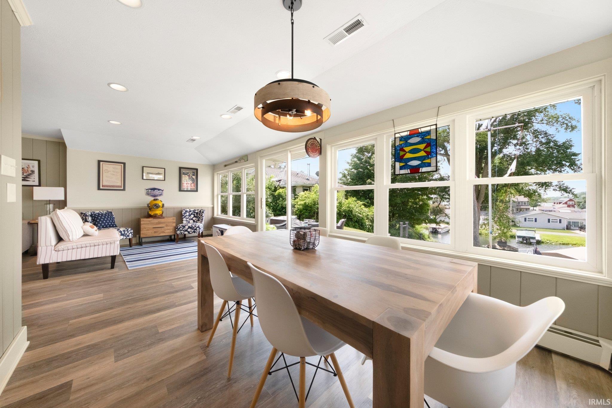 Open-concept living space with wood-finish flooring, recessed lighting, and a vaulted ceiling