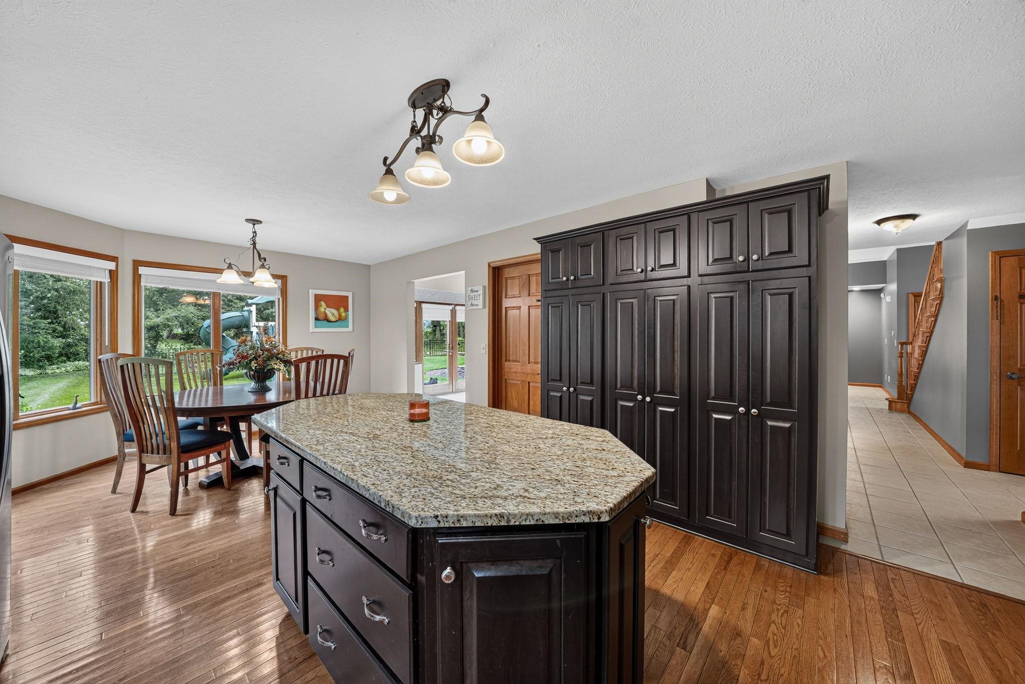Kitchen island featuring a granite countertop and dark wood cabinetry