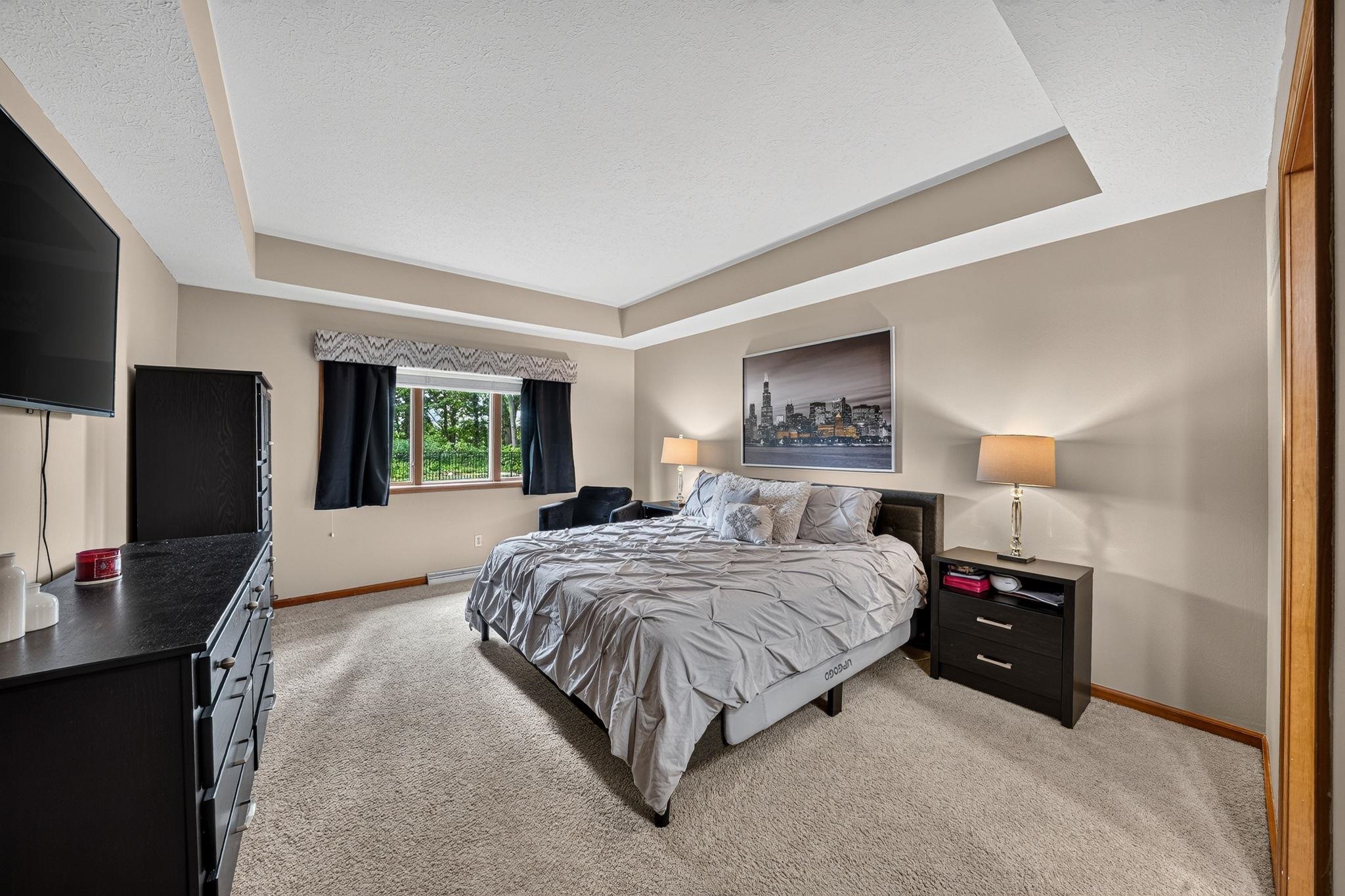 Recessed ceiling detail and neutral wall tones define this expansive room