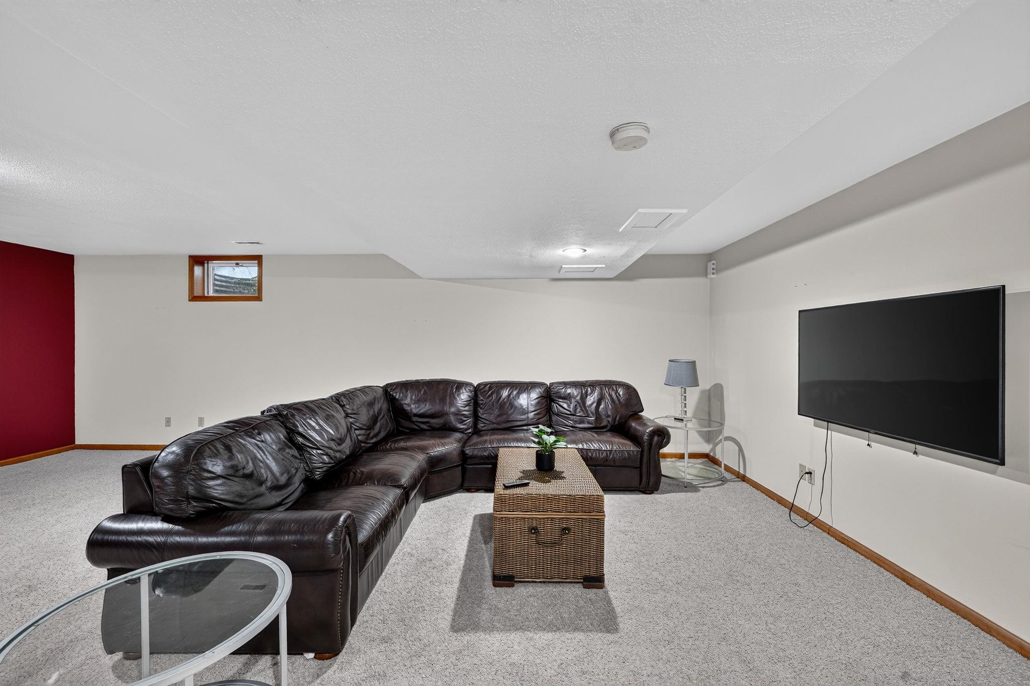 Spacious finished room with light-colored carpeting and recessed lighting