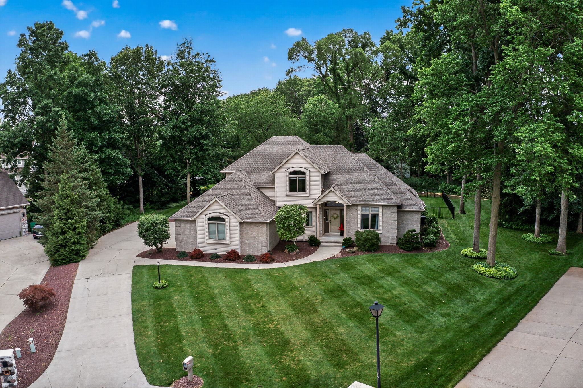 Stately residence with a light brick exterior and gray shingle roof
