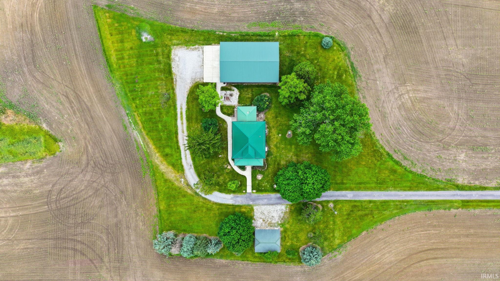 Aerial rendering of a property featuring a main residence, an auxiliary building, and a separate small structure, all with green roofs