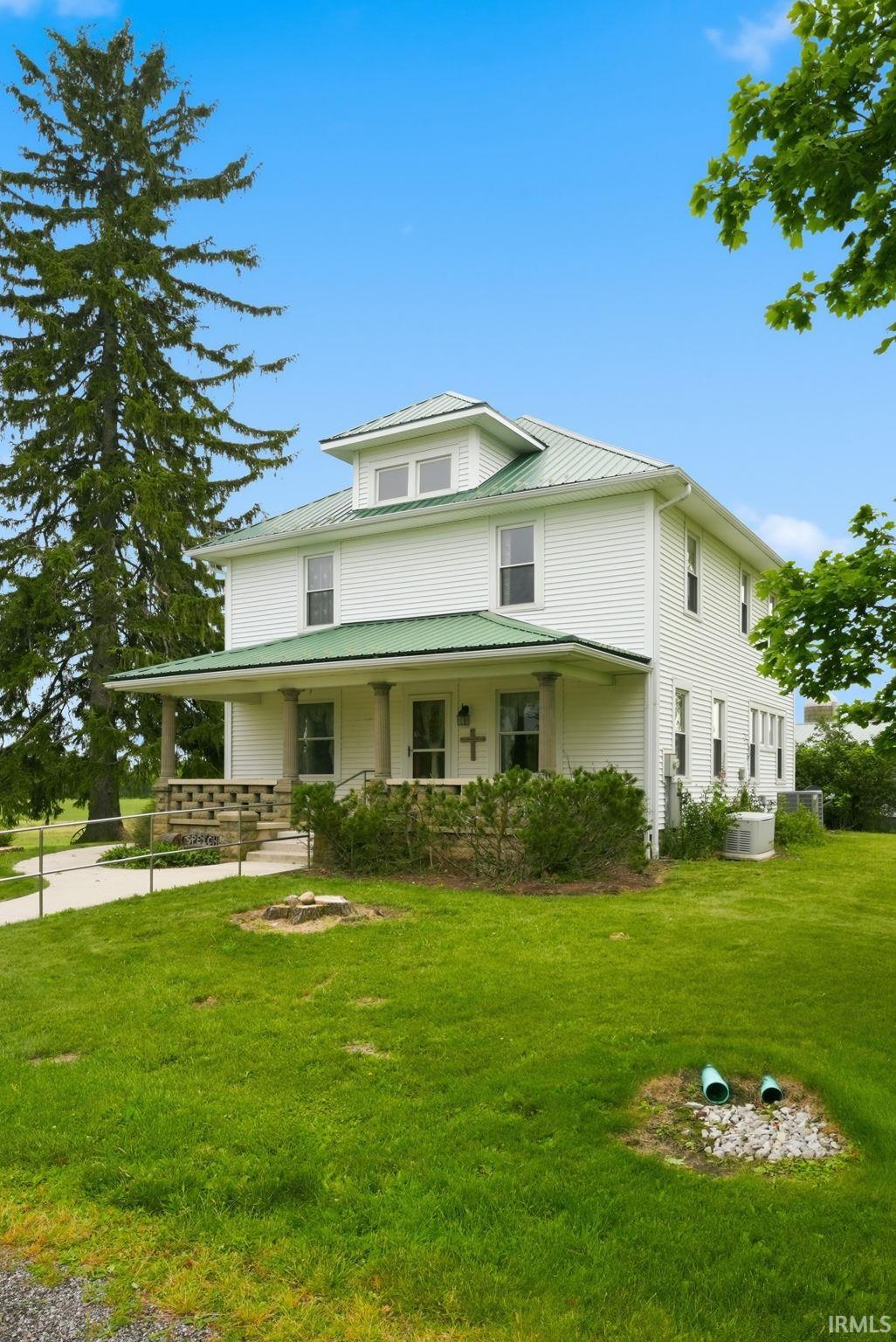 Two-story residence featuring white siding and a green metal roof