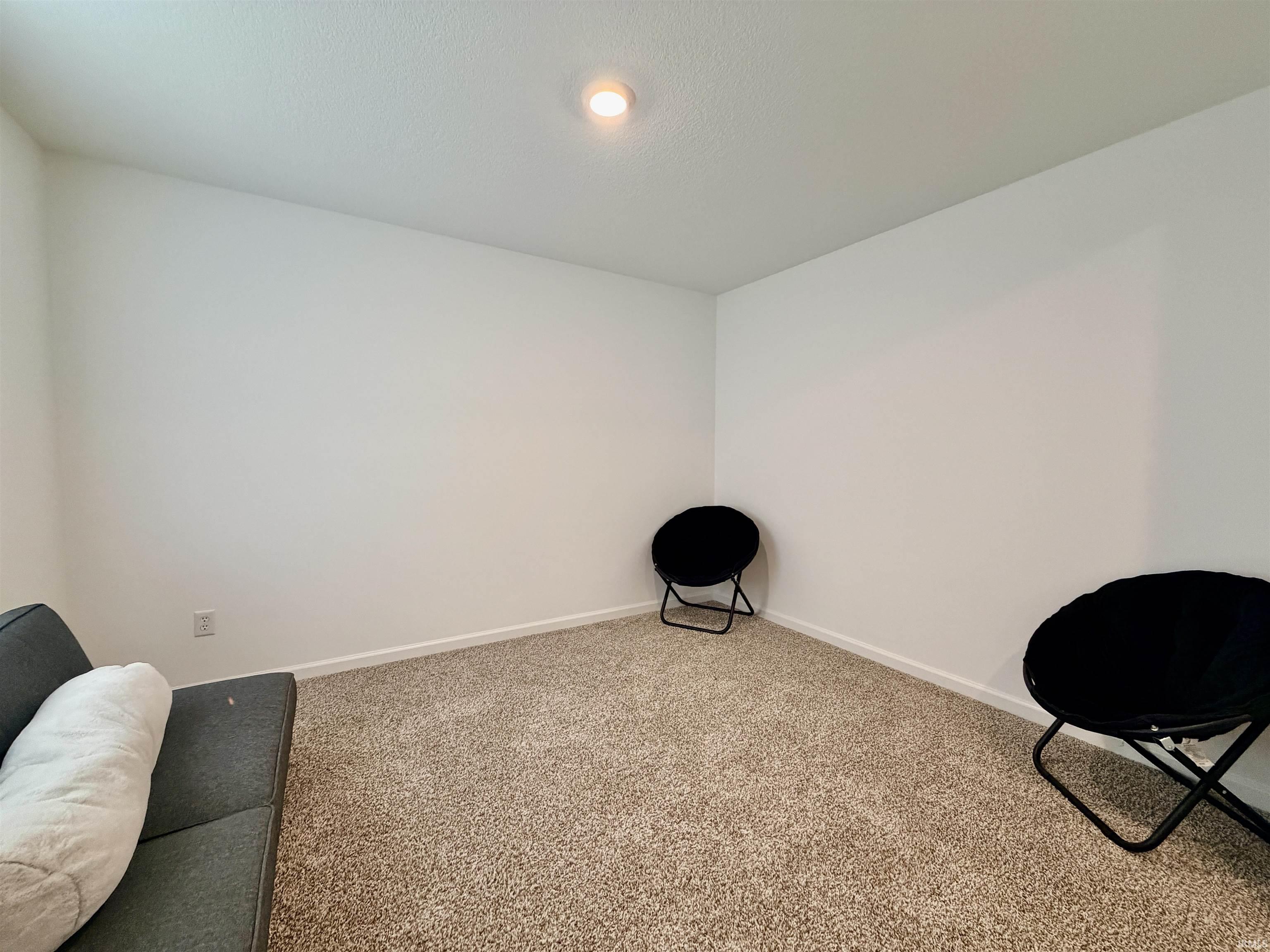 Carpeted room featuring white walls, white baseboards, and a recessed ceiling light fixture
