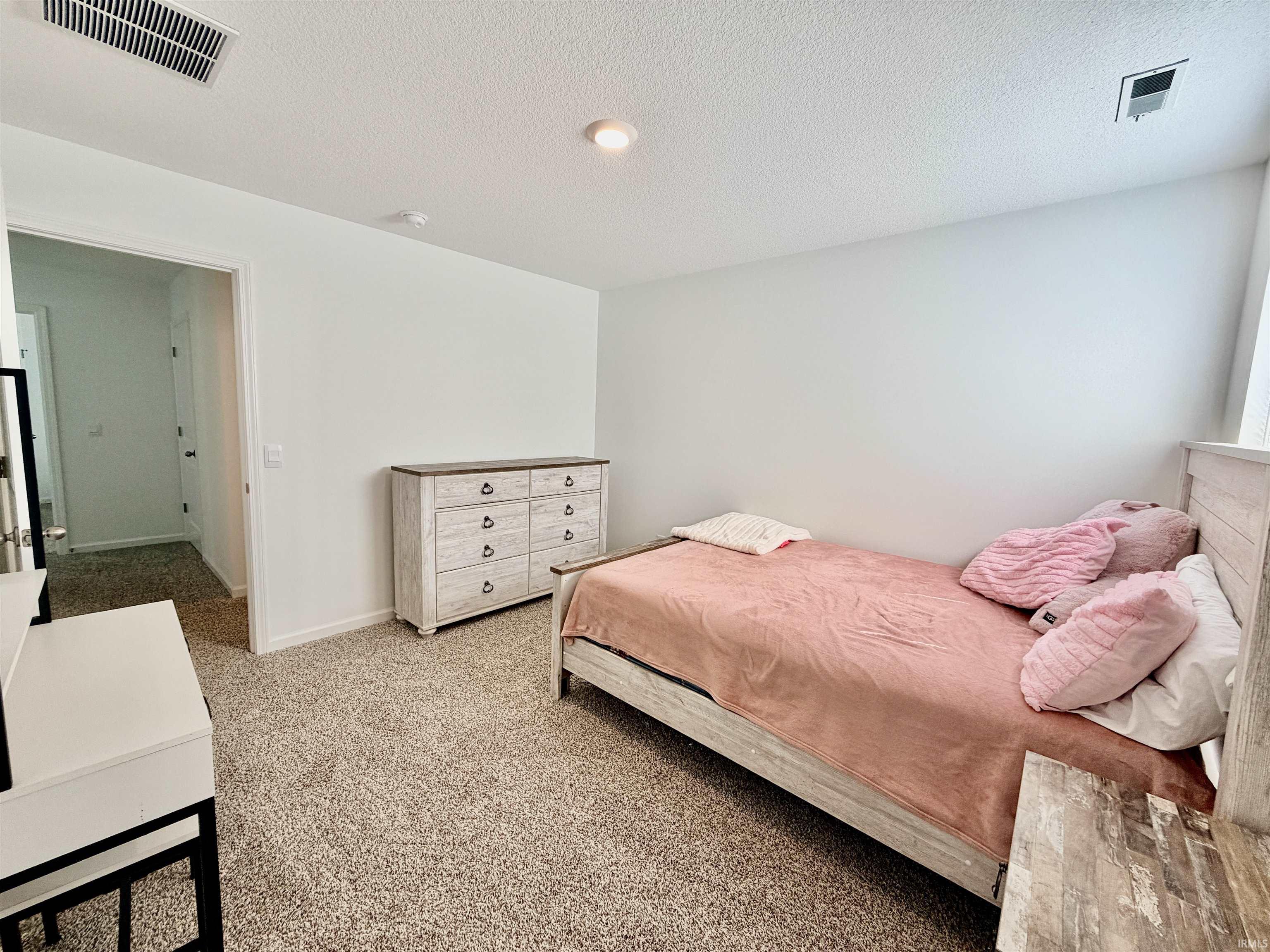 Spacious room featuring neutral carpet flooring, recessed ceiling lighting, and a white wall finish