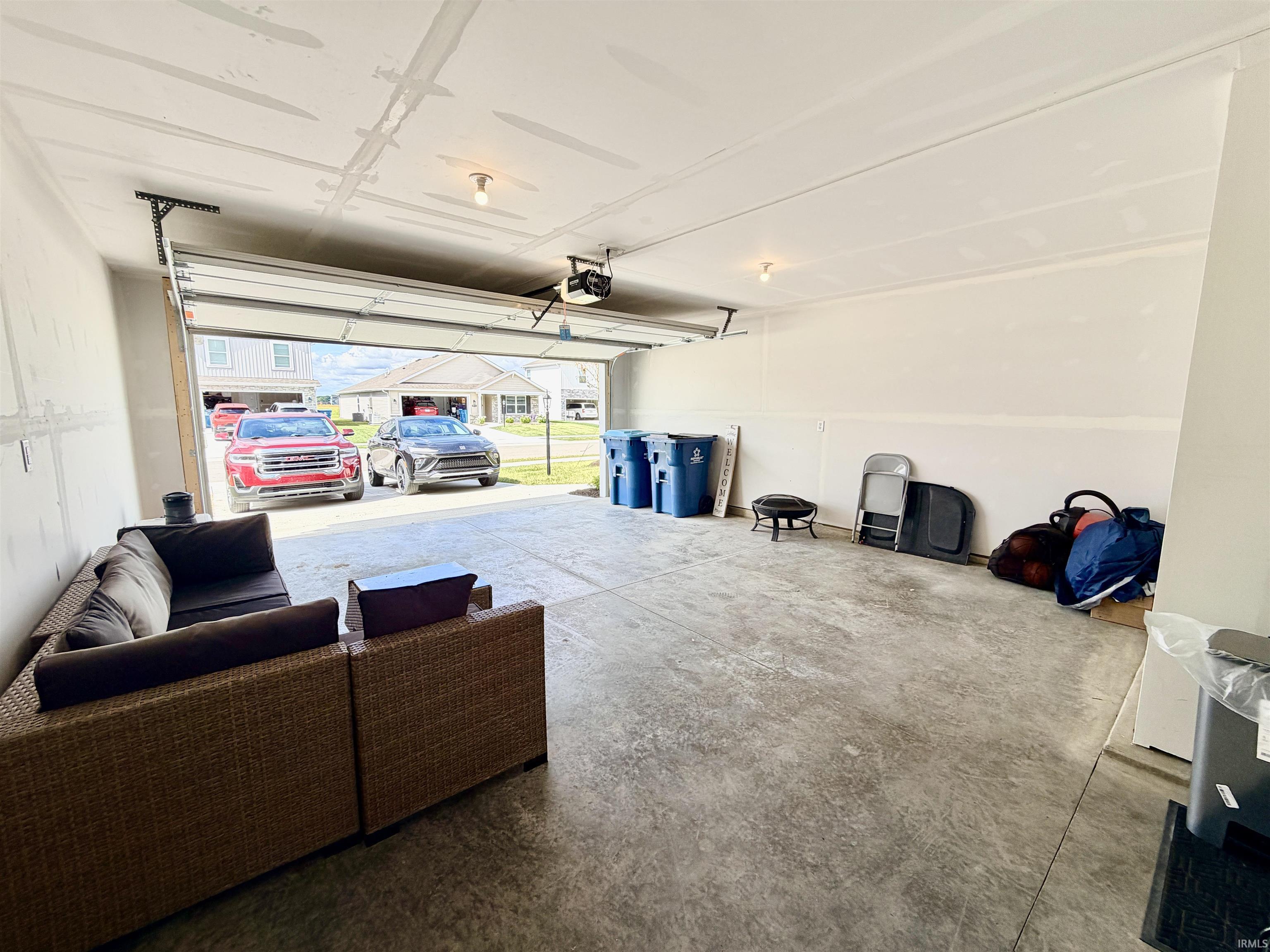 Spacious garage with concrete flooring and exposed ceiling joists