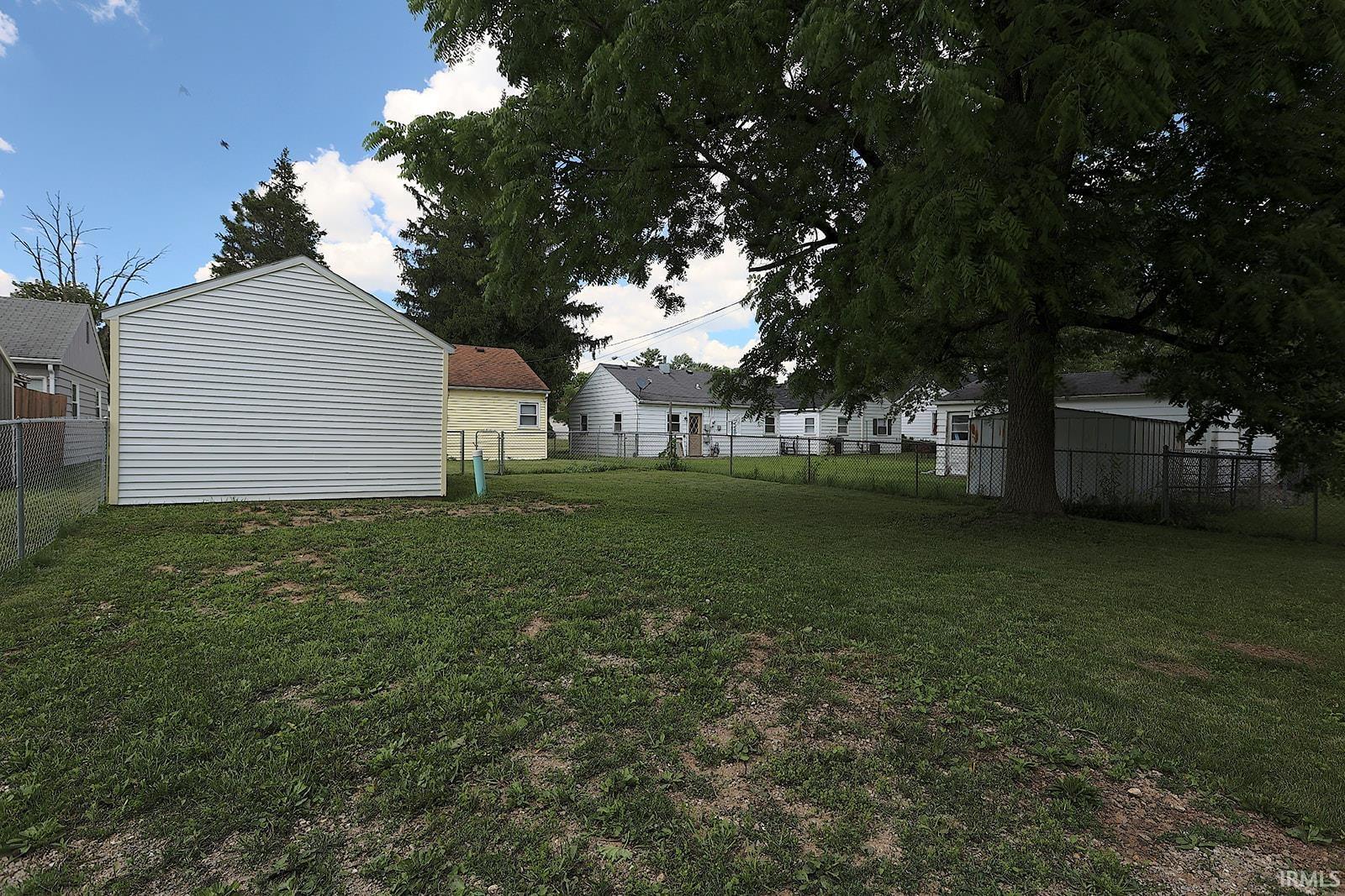 Expansive grassy yard with mature trees providing extensive shade