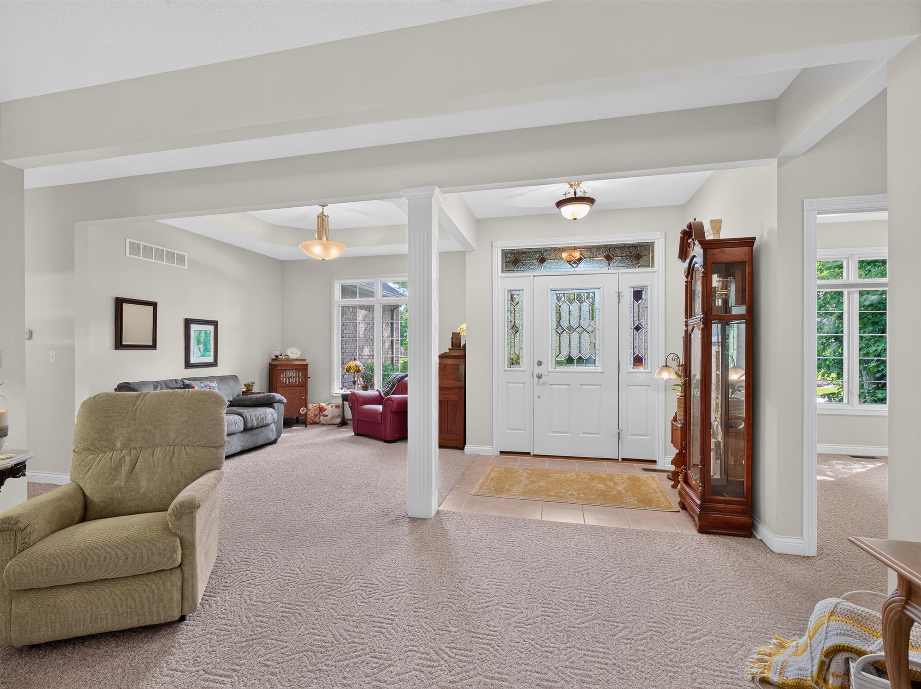 Entryway featuring a white door with decorative glass, sidelights, and a transom window