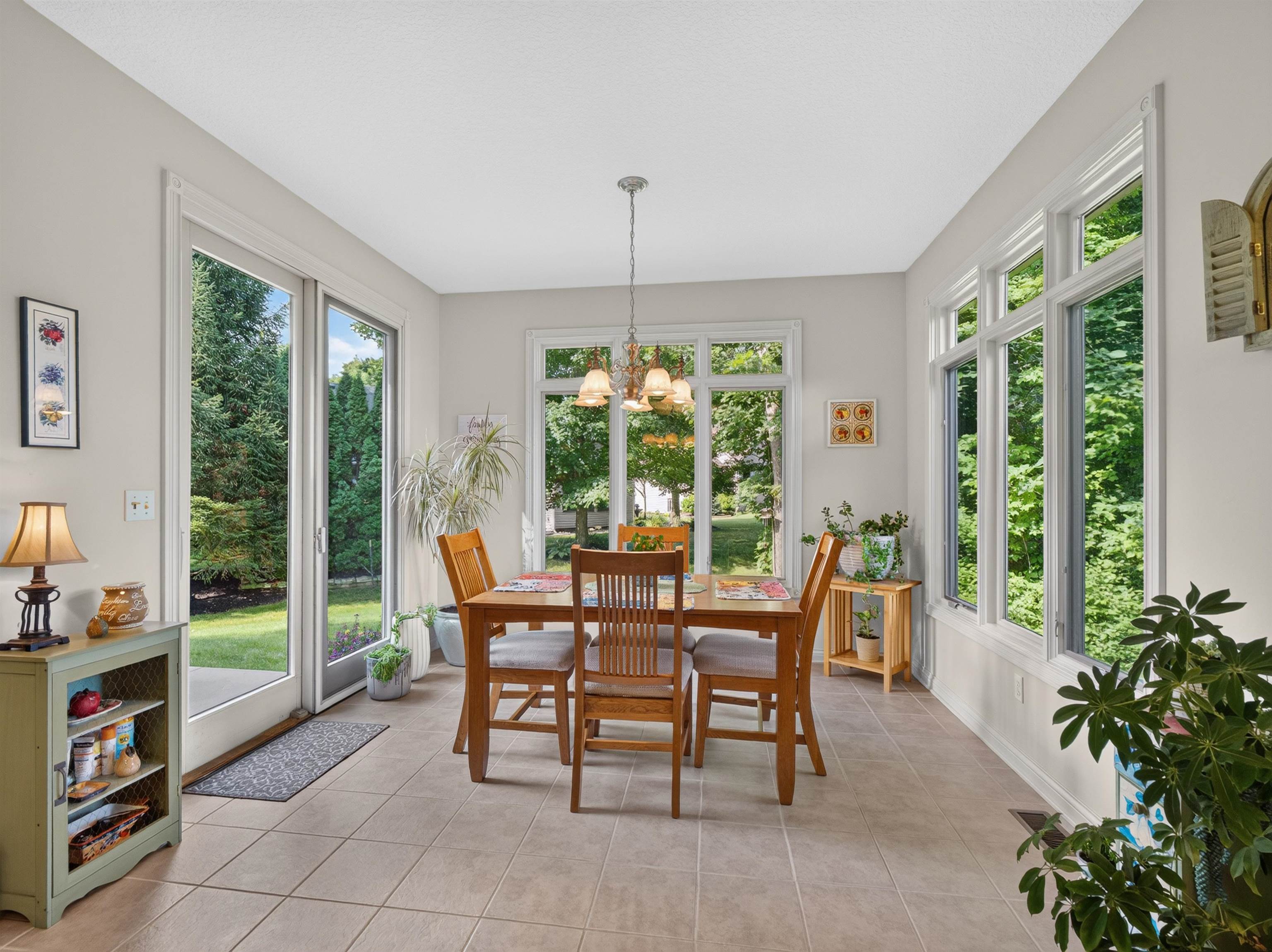Bright dining area featuring tile flooring, a multi-pane window wall, and sliding glass doors providing outdoor access