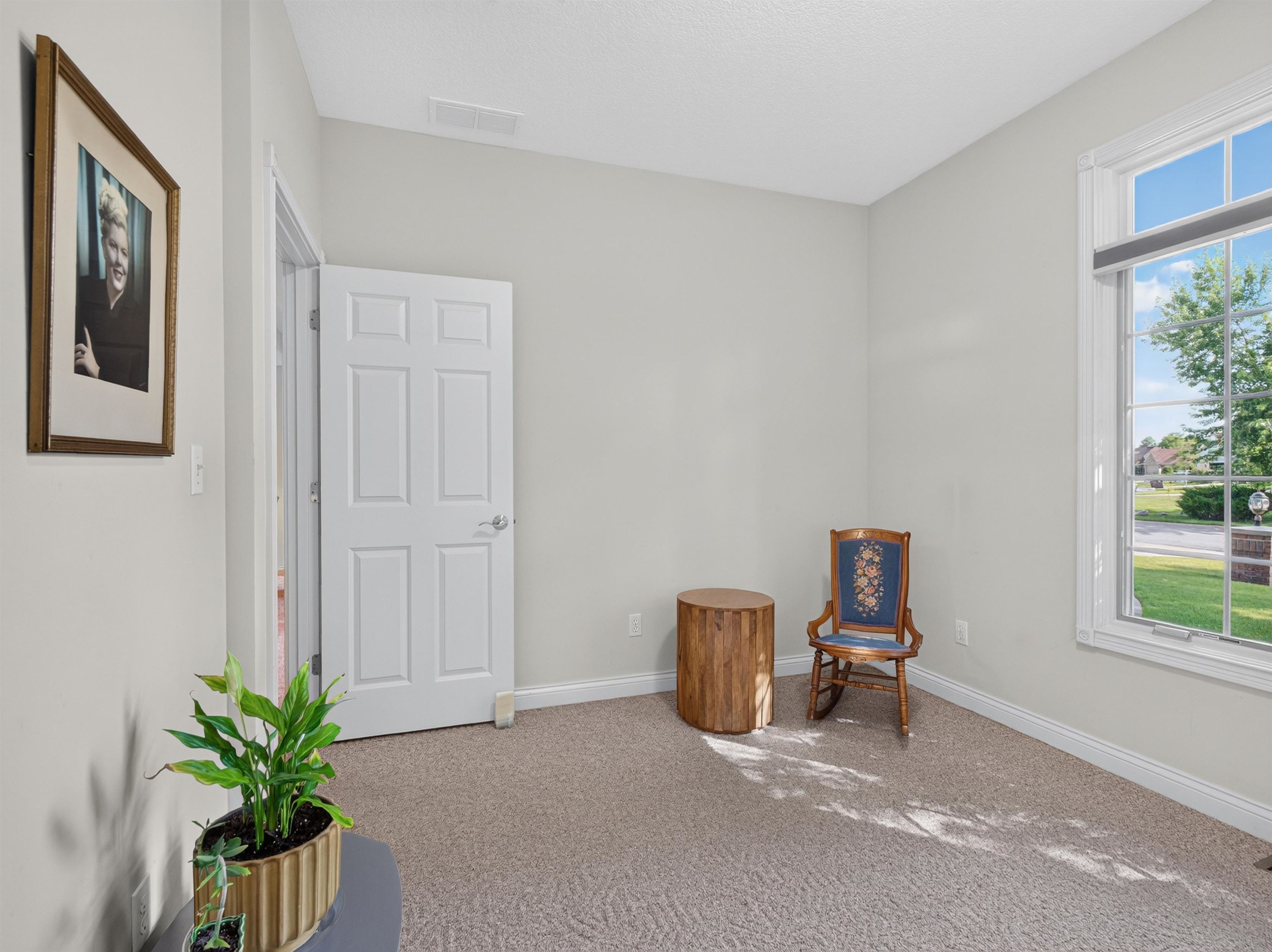 Light gray walls complement the neutral tone carpet flooring