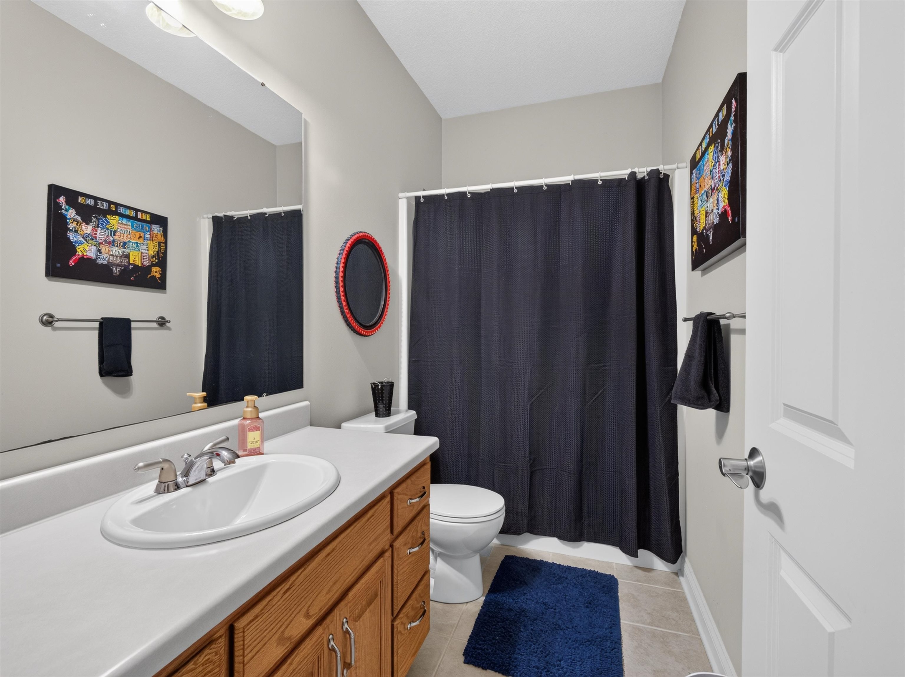 Bathroom featuring a single vanity with wood cabinetry, a white countertop, and a chrome faucet