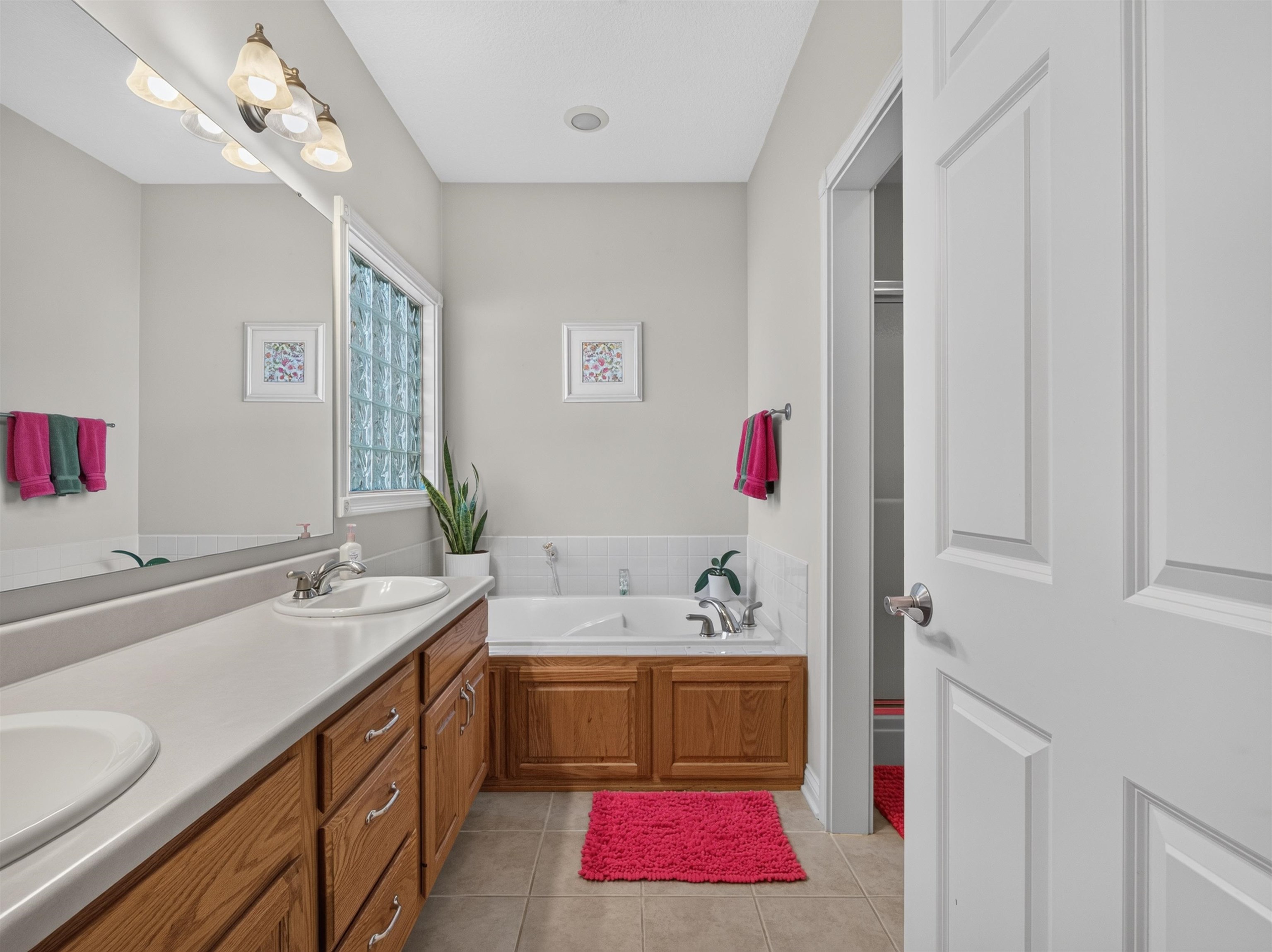 Dual vanity with light-colored countertops and wood-finish cabinetry