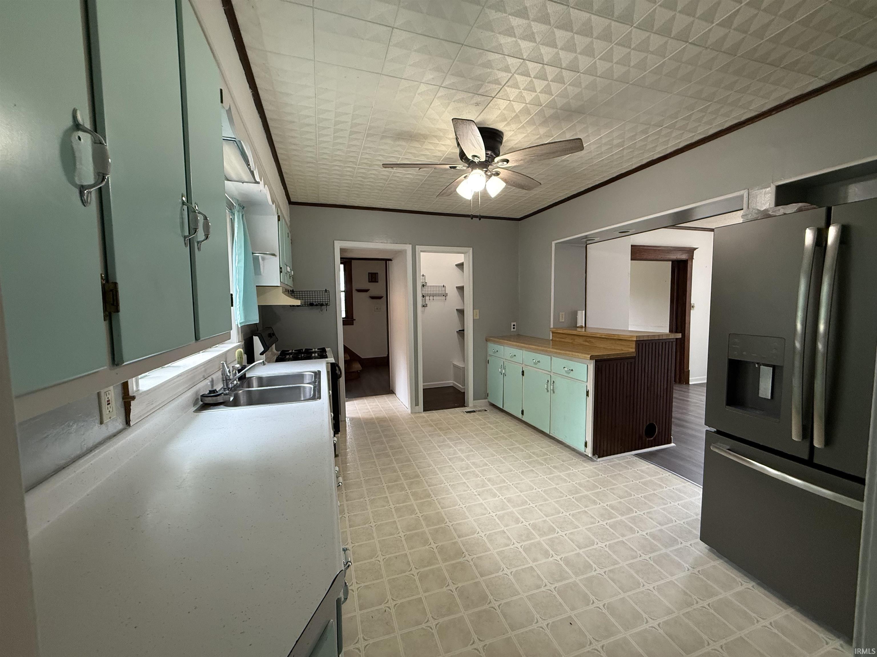 Kitchen featuring a double basin stainless steel sink, light blue cabinetry, and a textured ceiling