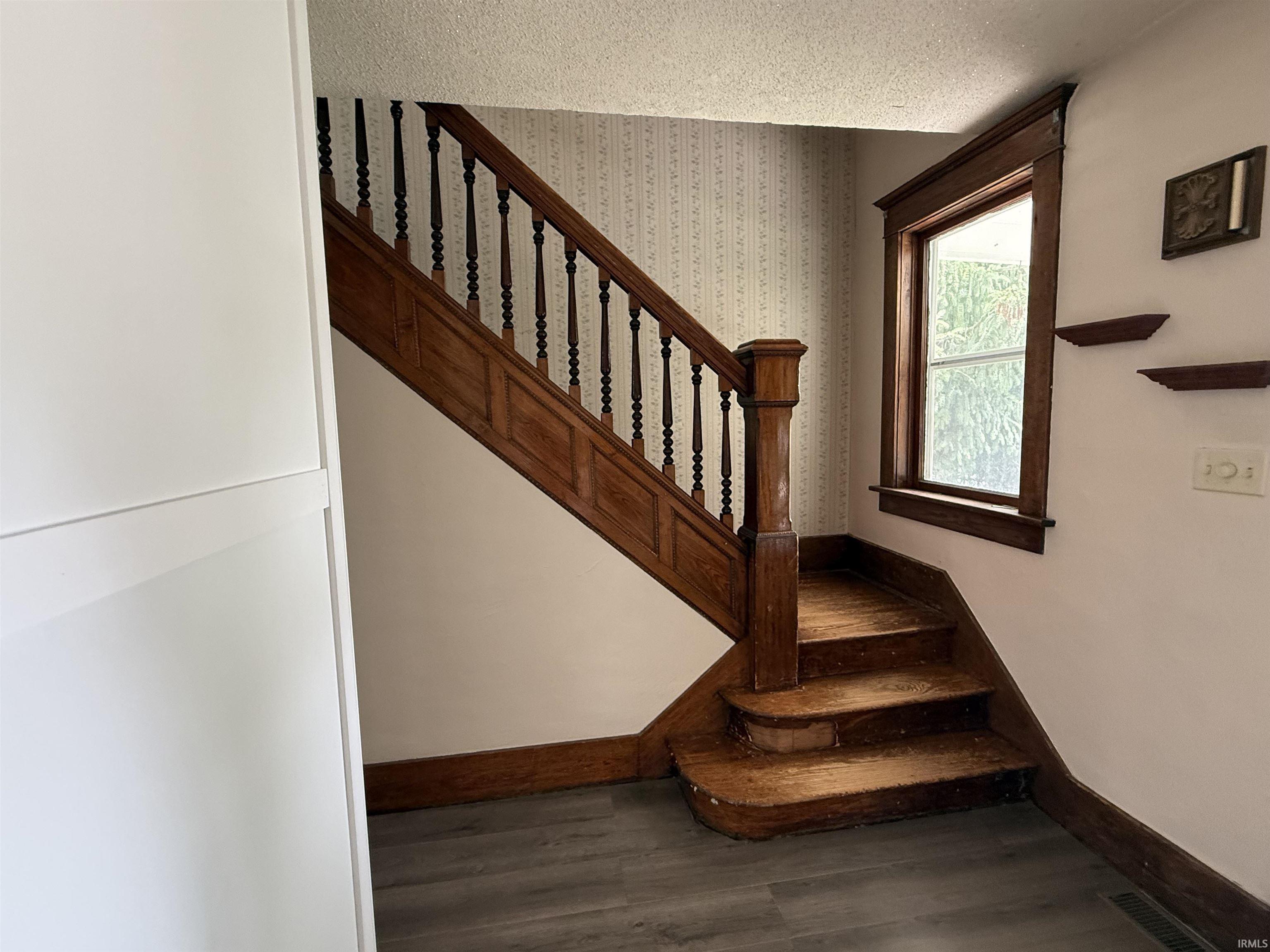Wooden staircase with carved newel post and balusters