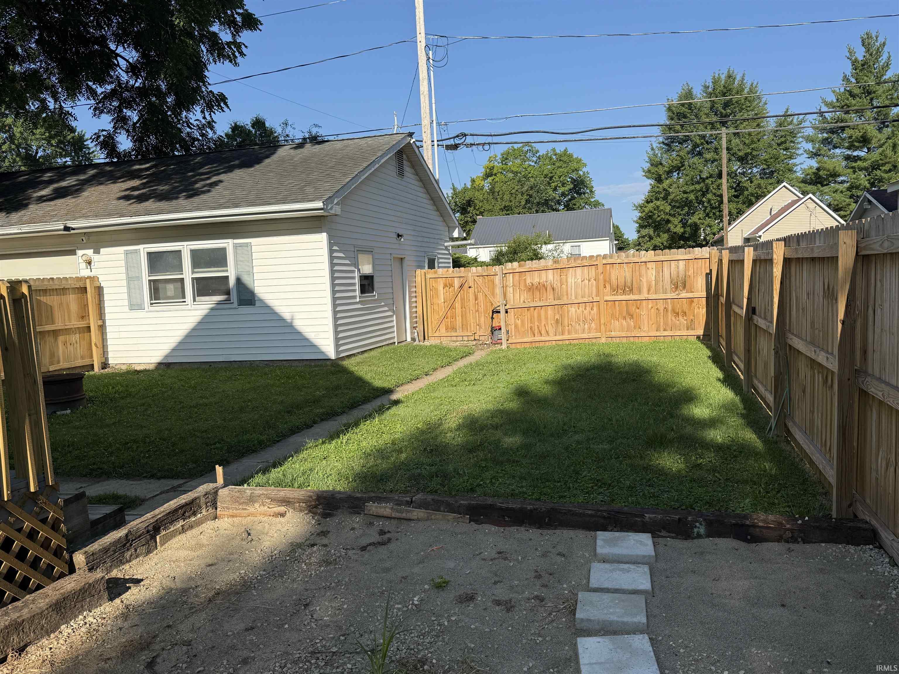 Private backyard featuring a full wood privacy fence and a manicured lawn