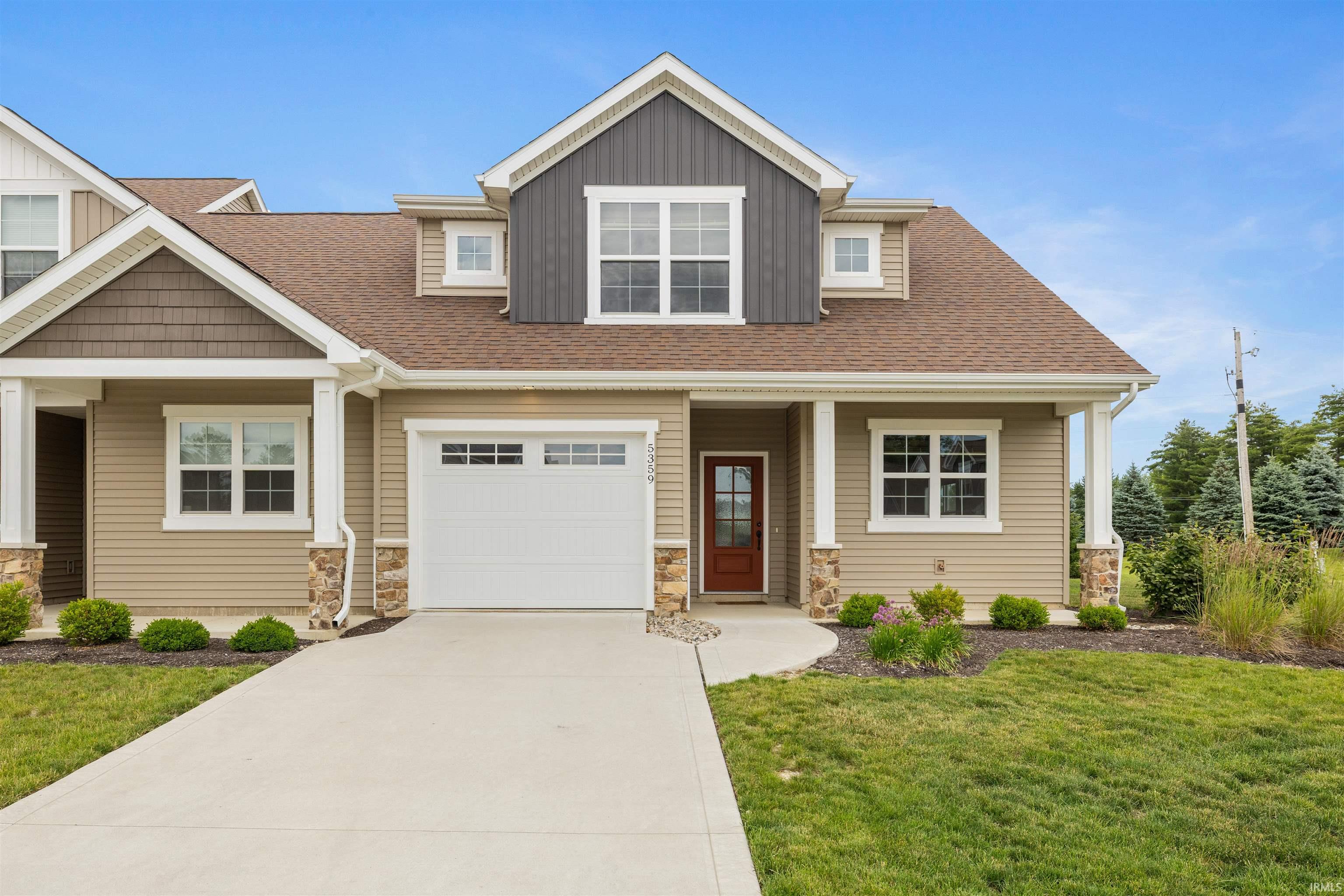 Contemporary facade featuring a mix of horizontal siding, shake siding, and stone accents