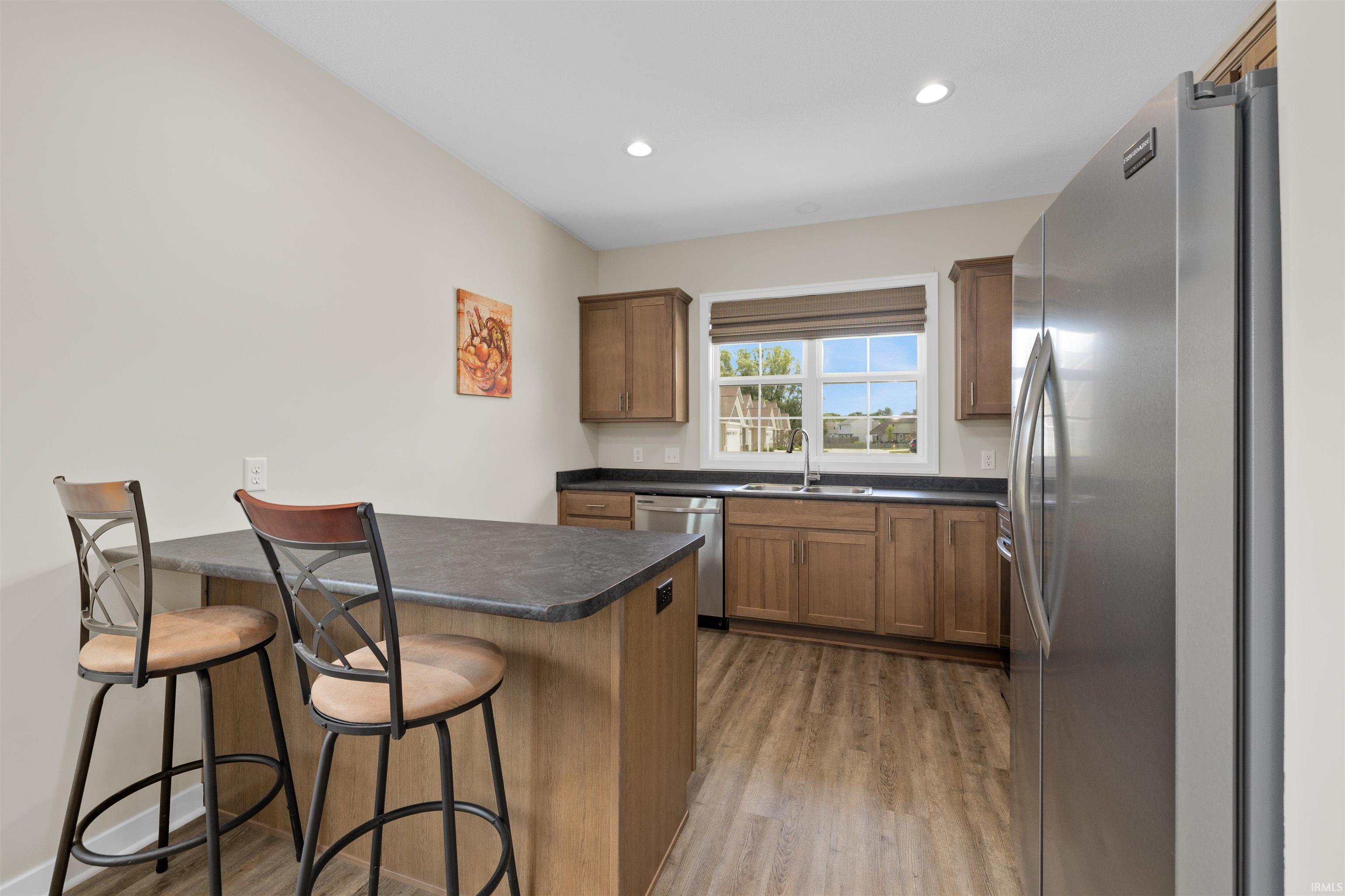 Kitchen featuring wood-finish flooring, recessed lighting, and a stainless steel refrigerator