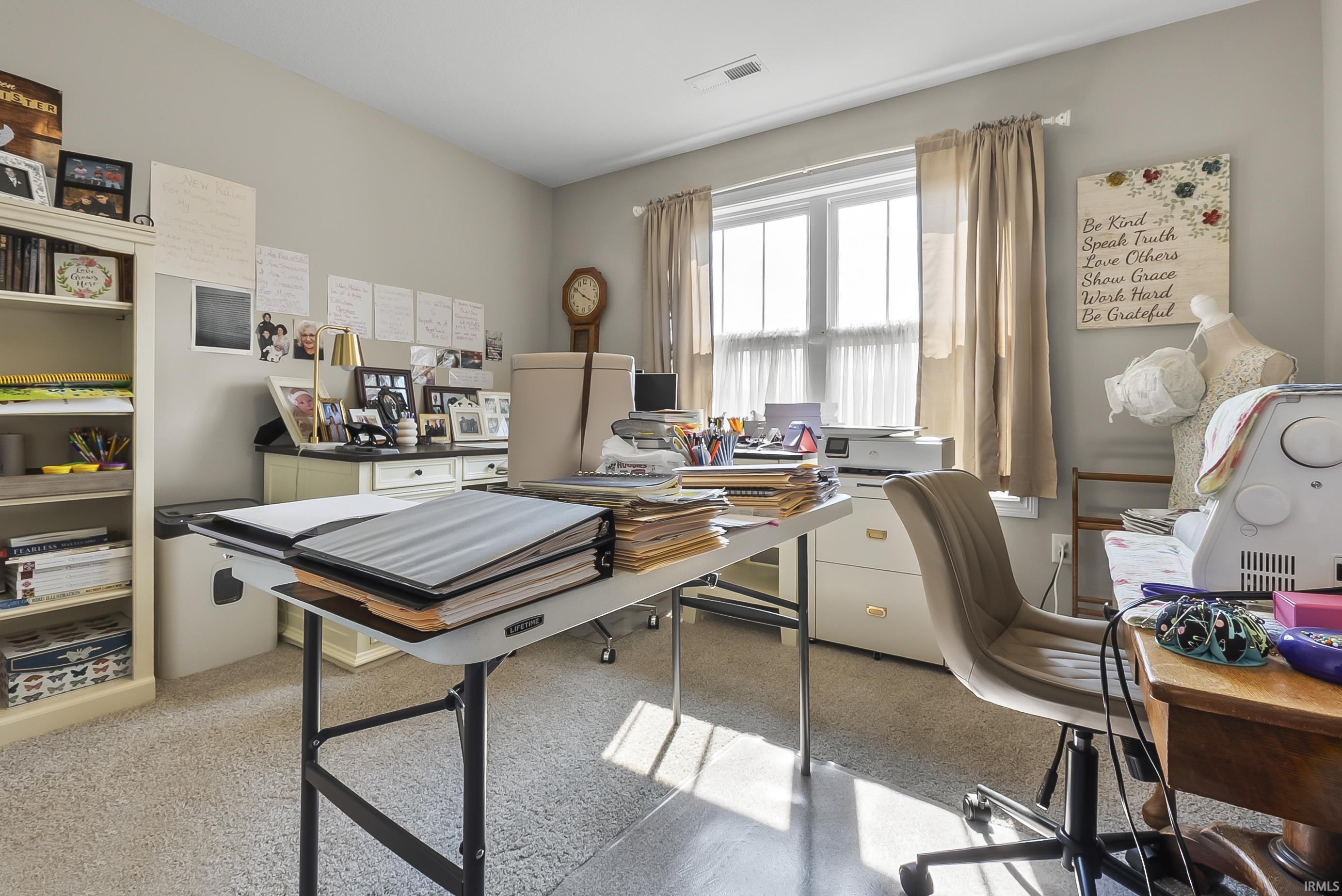 Neutral-toned walls and plush carpet flooring complement a large window with natural light