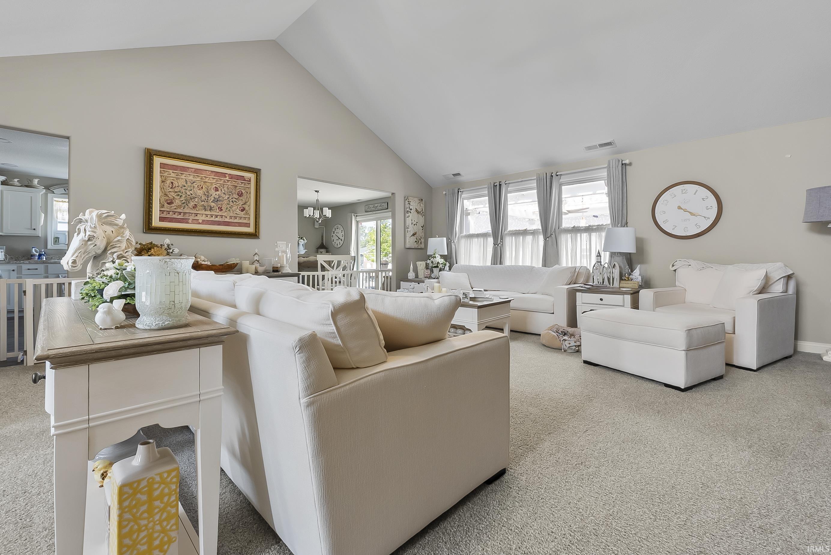 Living area featuring a vaulted ceiling and light-toned wall finishes
