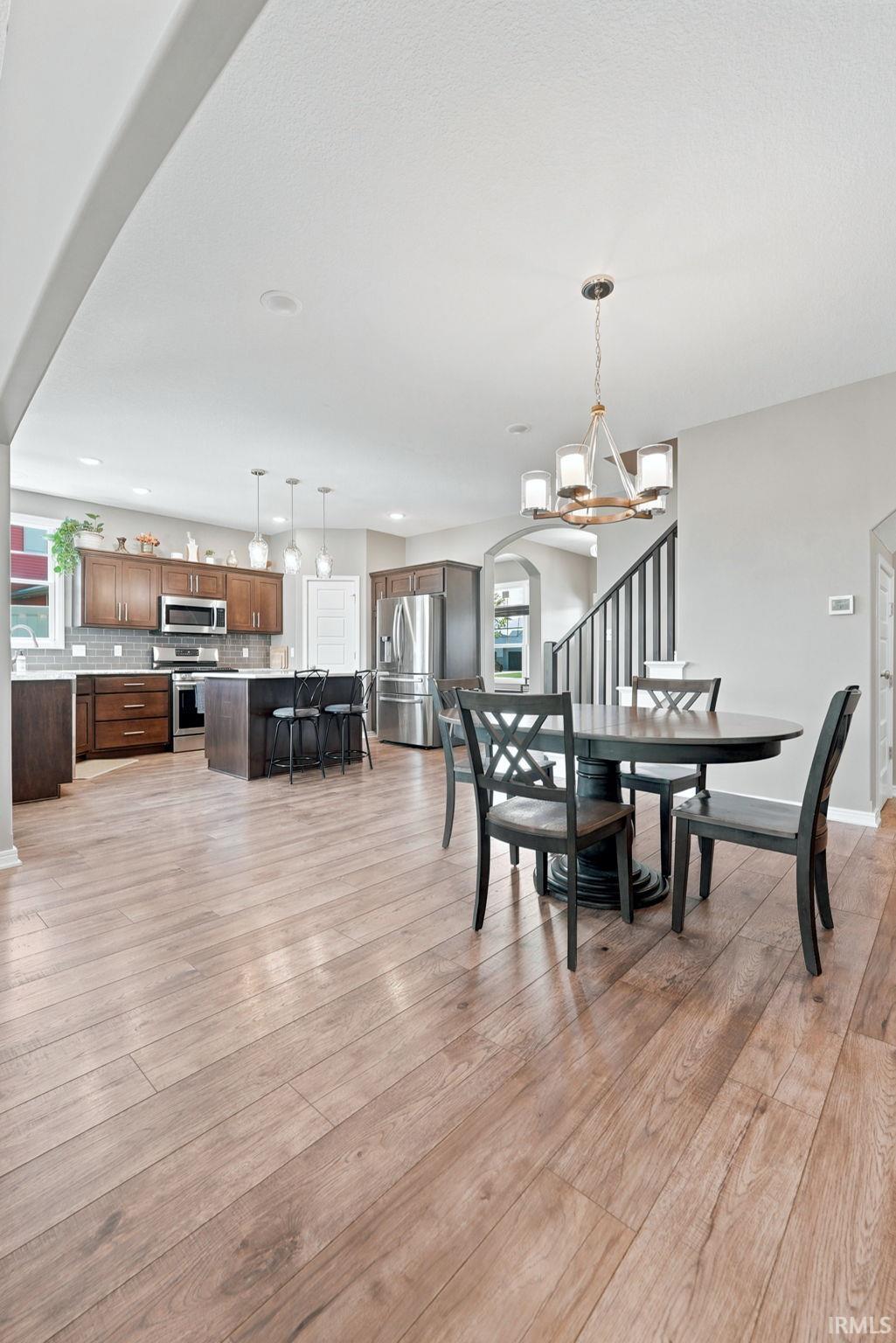 Expansive wood-finish flooring throughout the dining area and kitchen