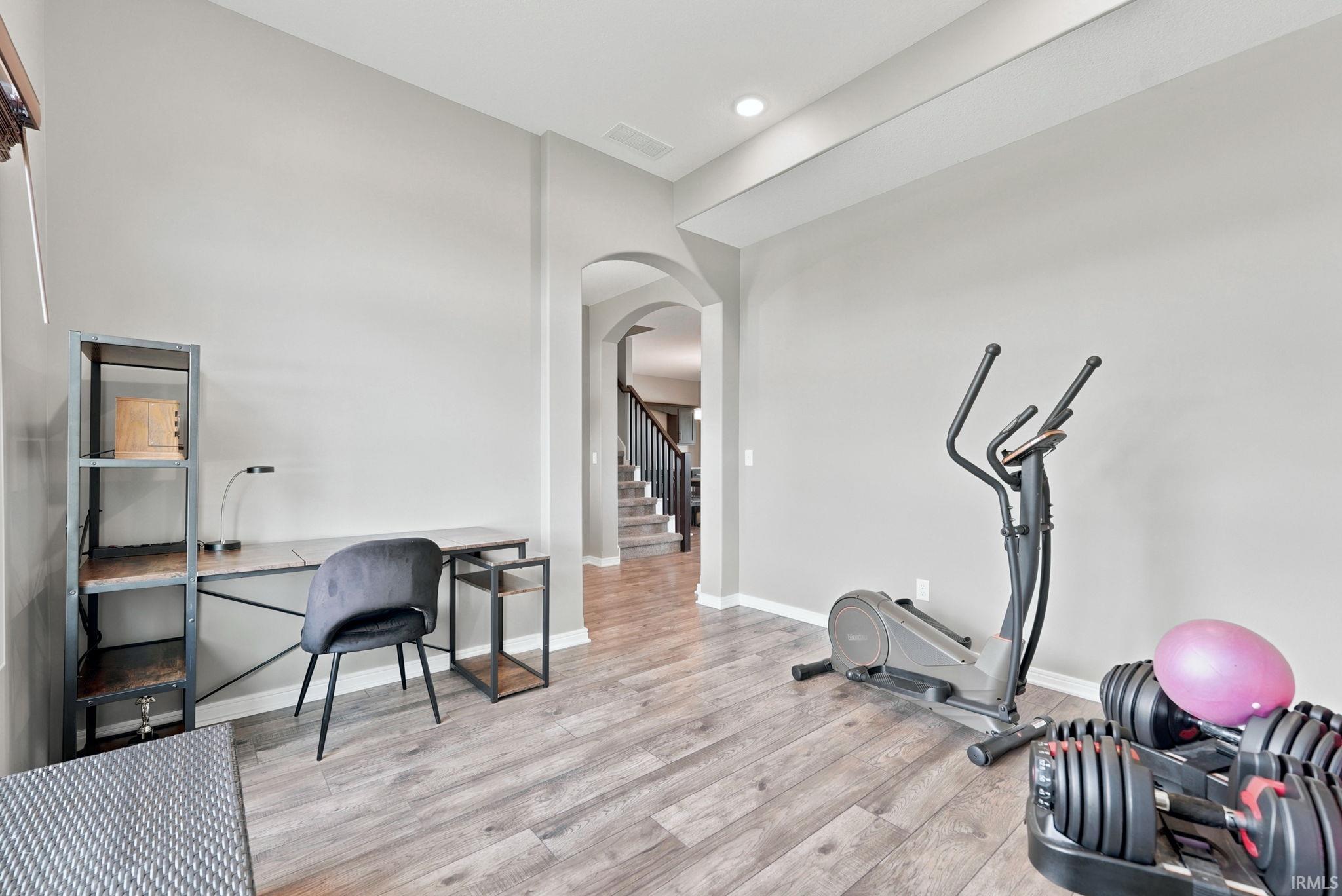 Versatile room featuring wood-finish flooring and neutral wall tones