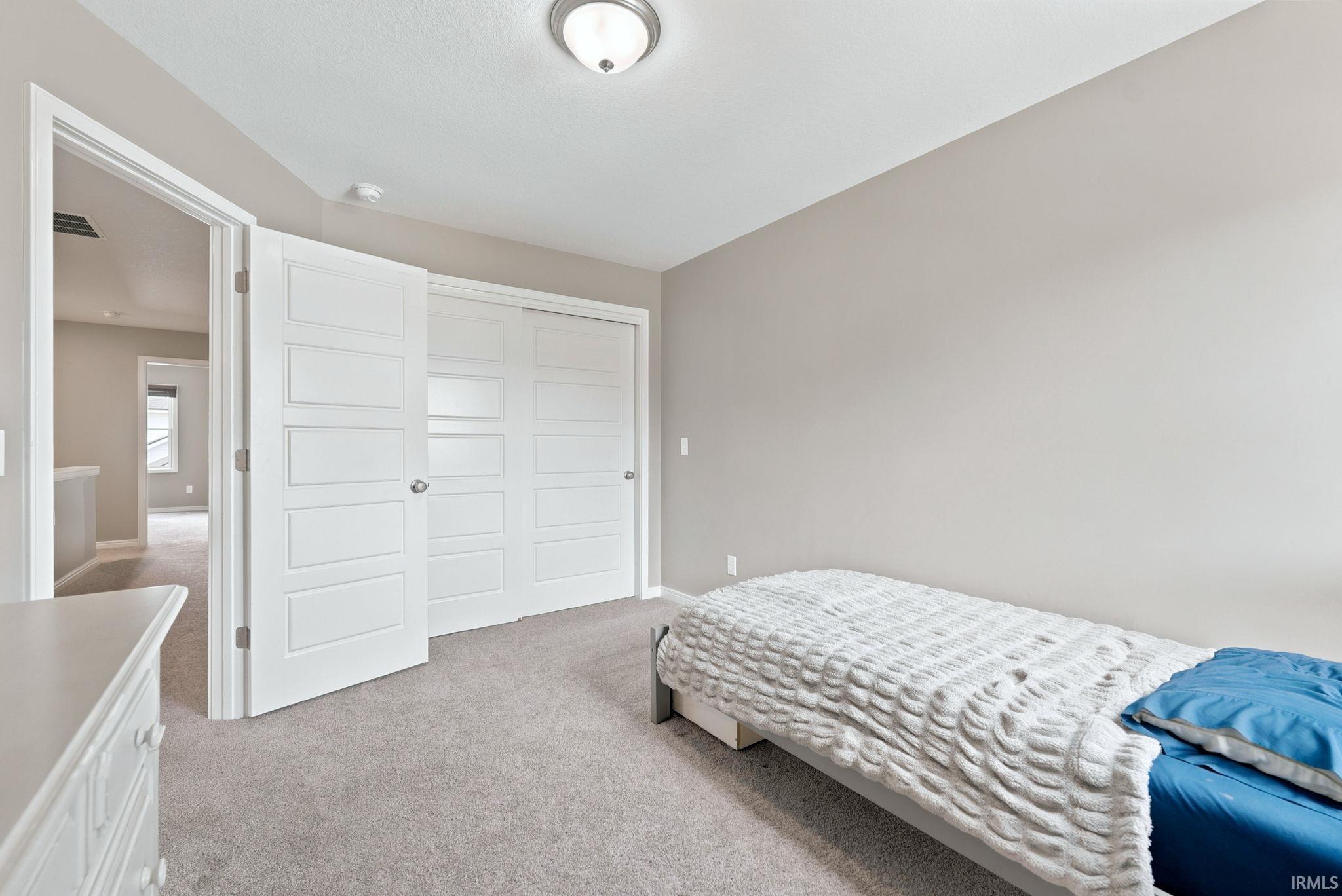 Neutral-toned interior room featuring light gray carpeting and a ceiling-mounted flush light fixture