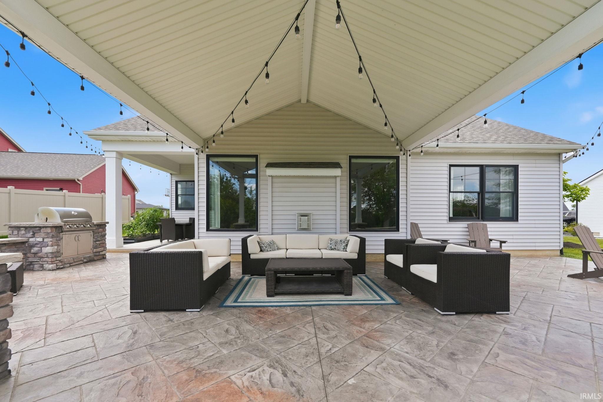 Covered outdoor living space featuring stamped concrete flooring