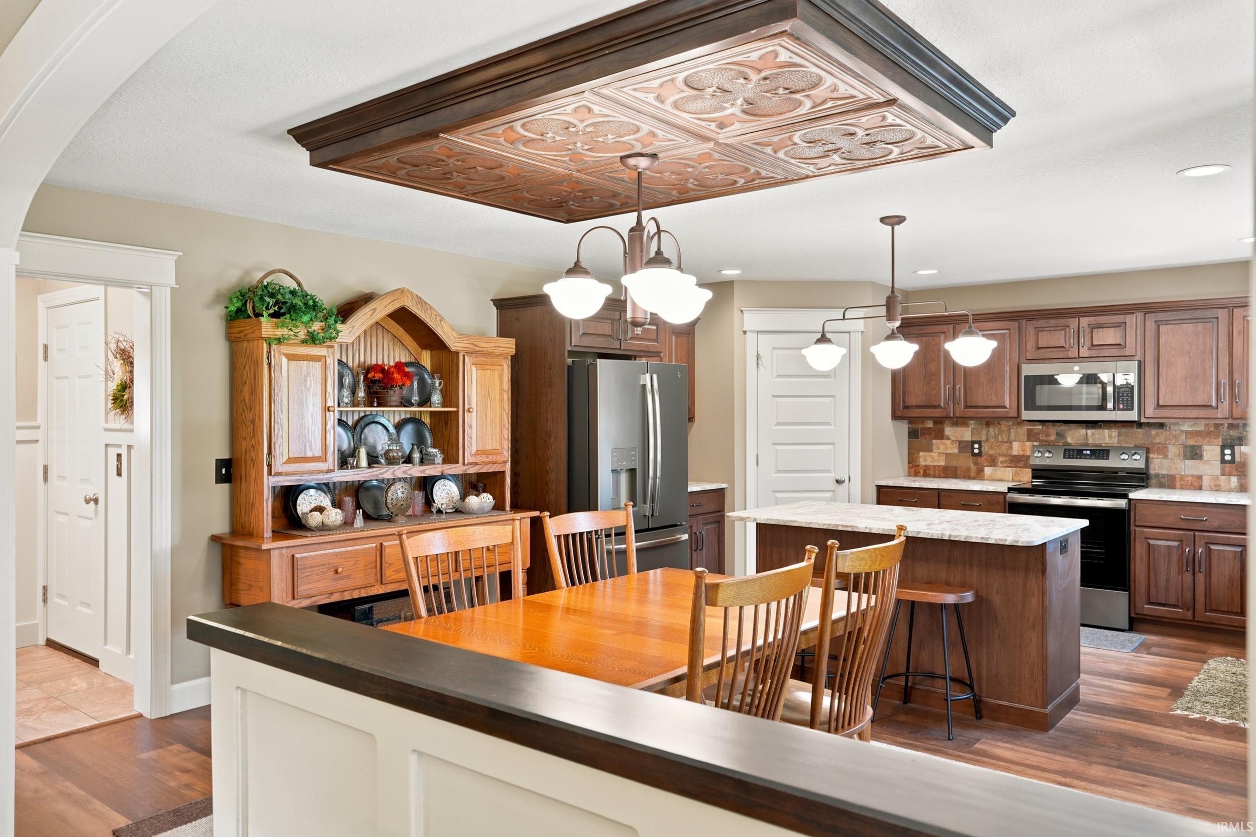 Kitchen featuring wood-finish flooring, dark wood cabinetry, and a granite-topped island with seating
