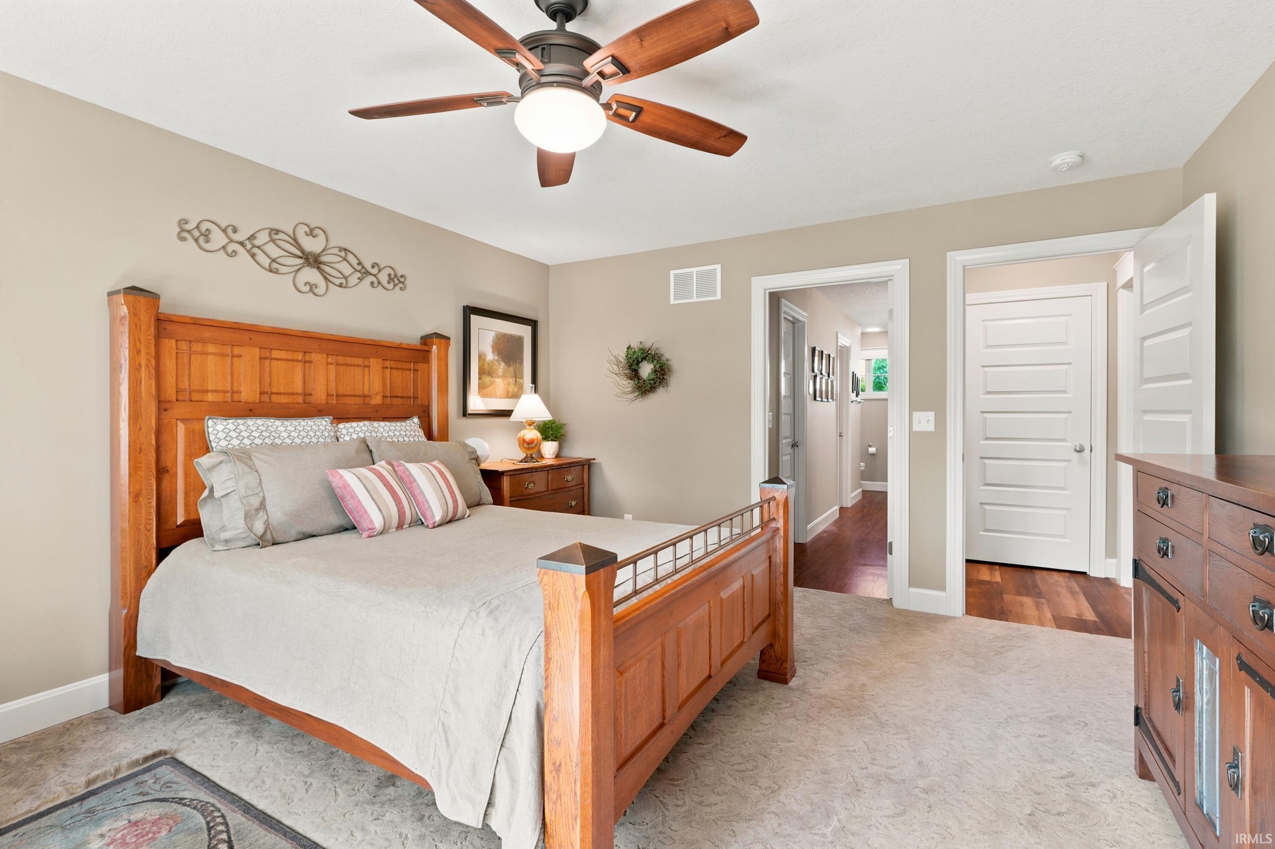 Carpeted bedroom featuring a ceiling fan, neutral wall paint, and white trim