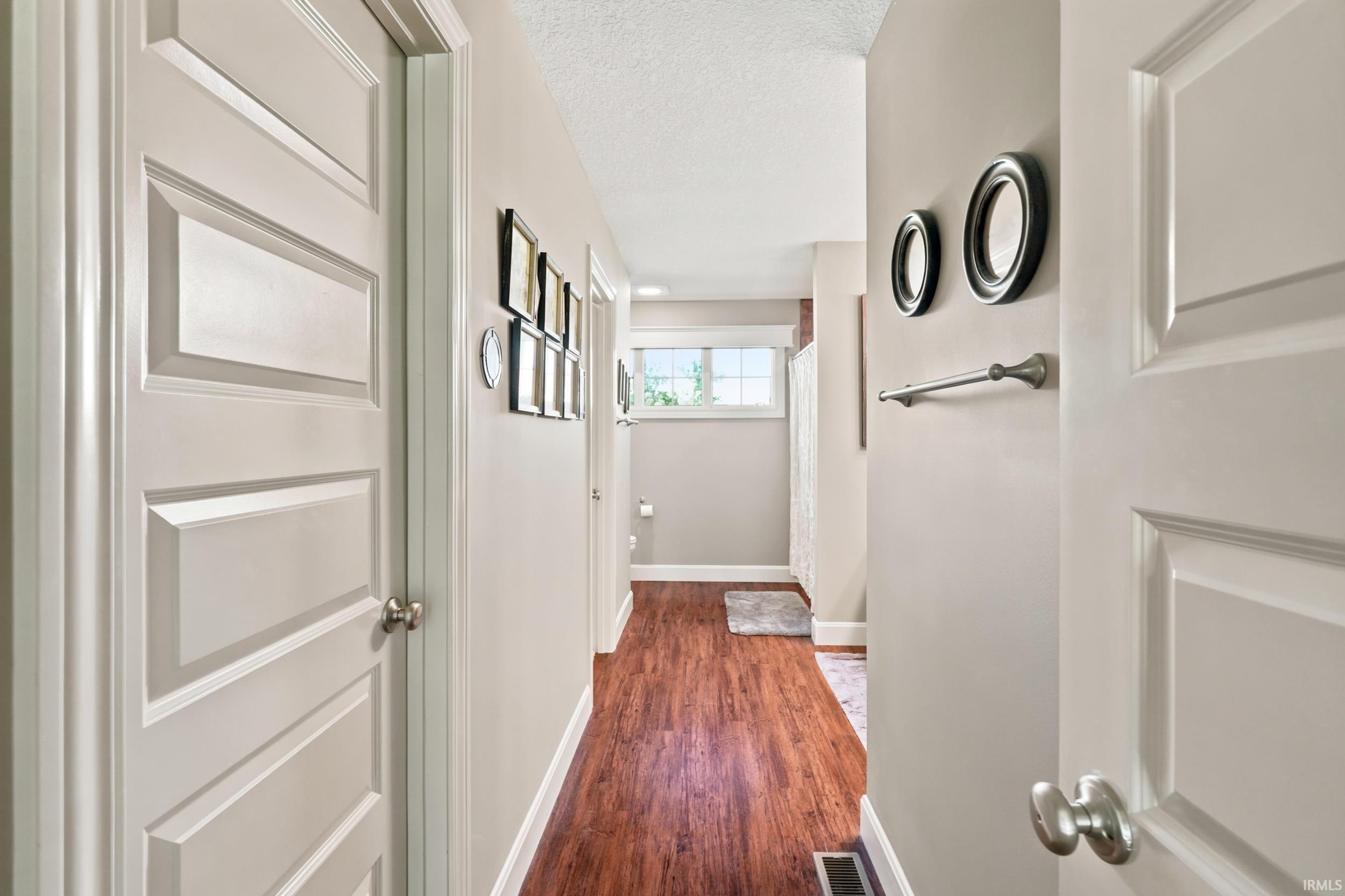Hallway featuring wood-finish flooring, recessed lighting, and neutral wall tones