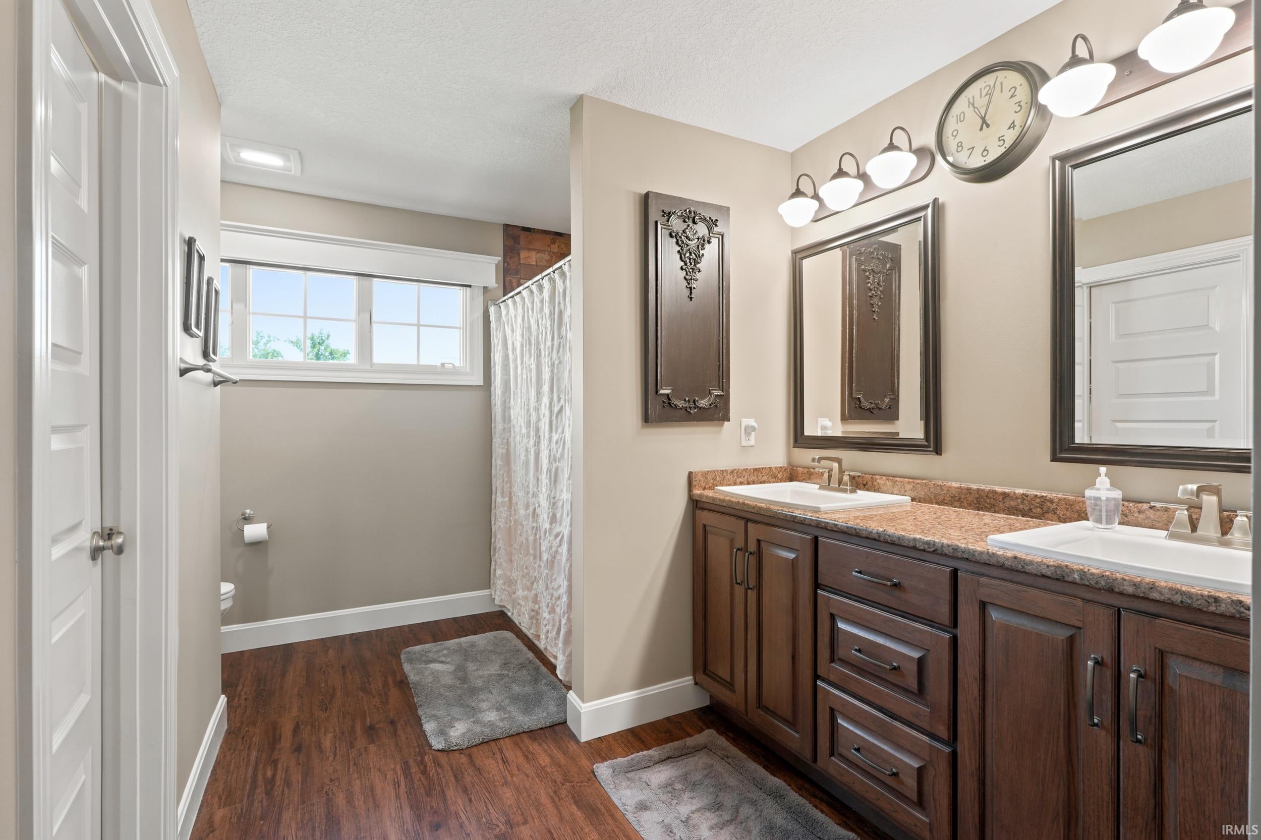 Dual vanity with wood-finish cabinetry and light-toned countertops