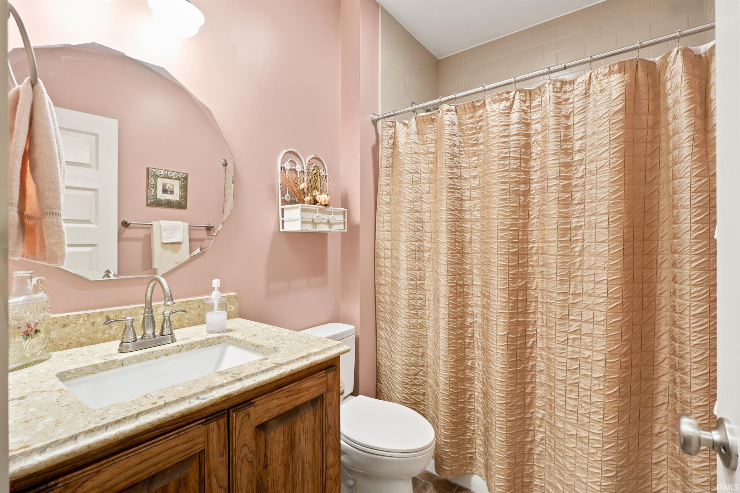Bathroom featuring a vanity with a light-toned countertop, an undermount sink, and a wood-finish cabinet