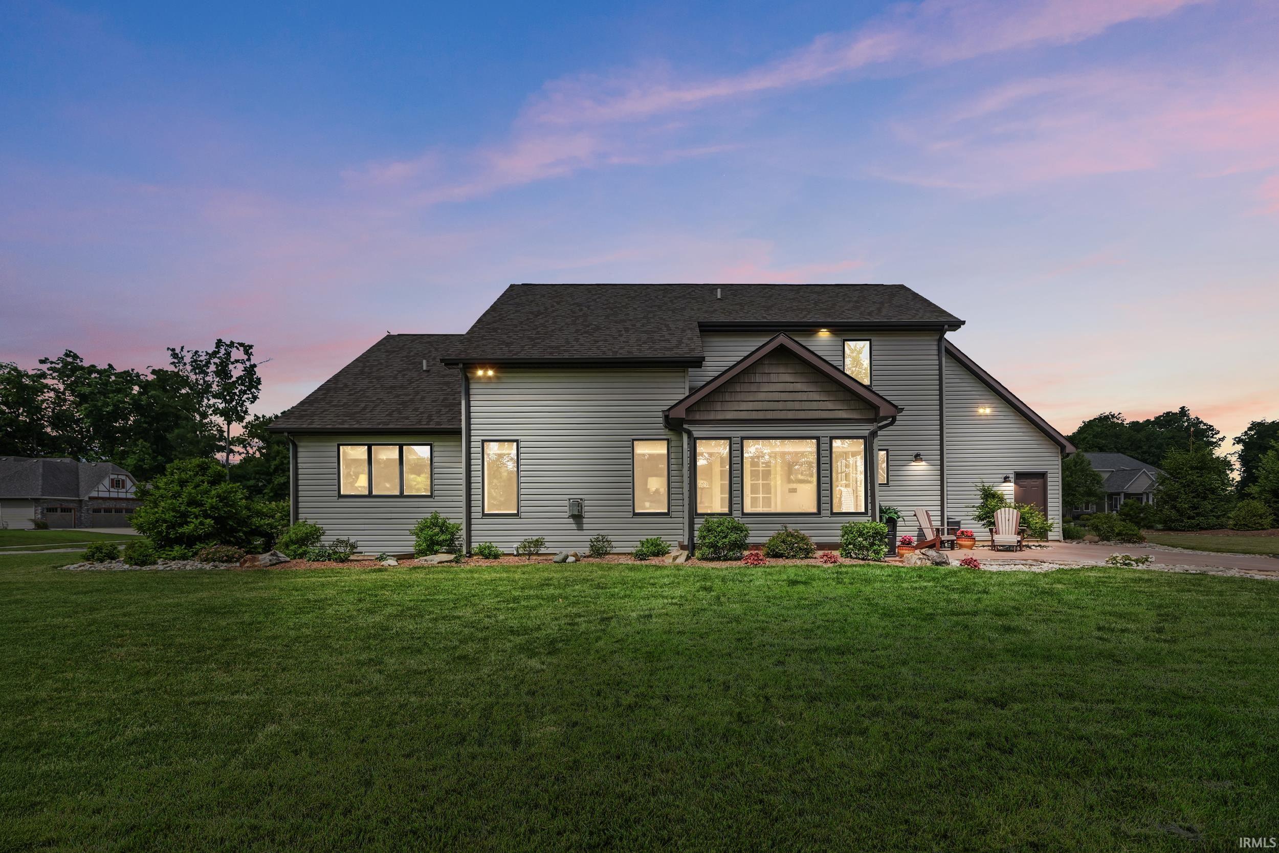 Expansive rear facade featuring horizontal siding and a dark shingle roof