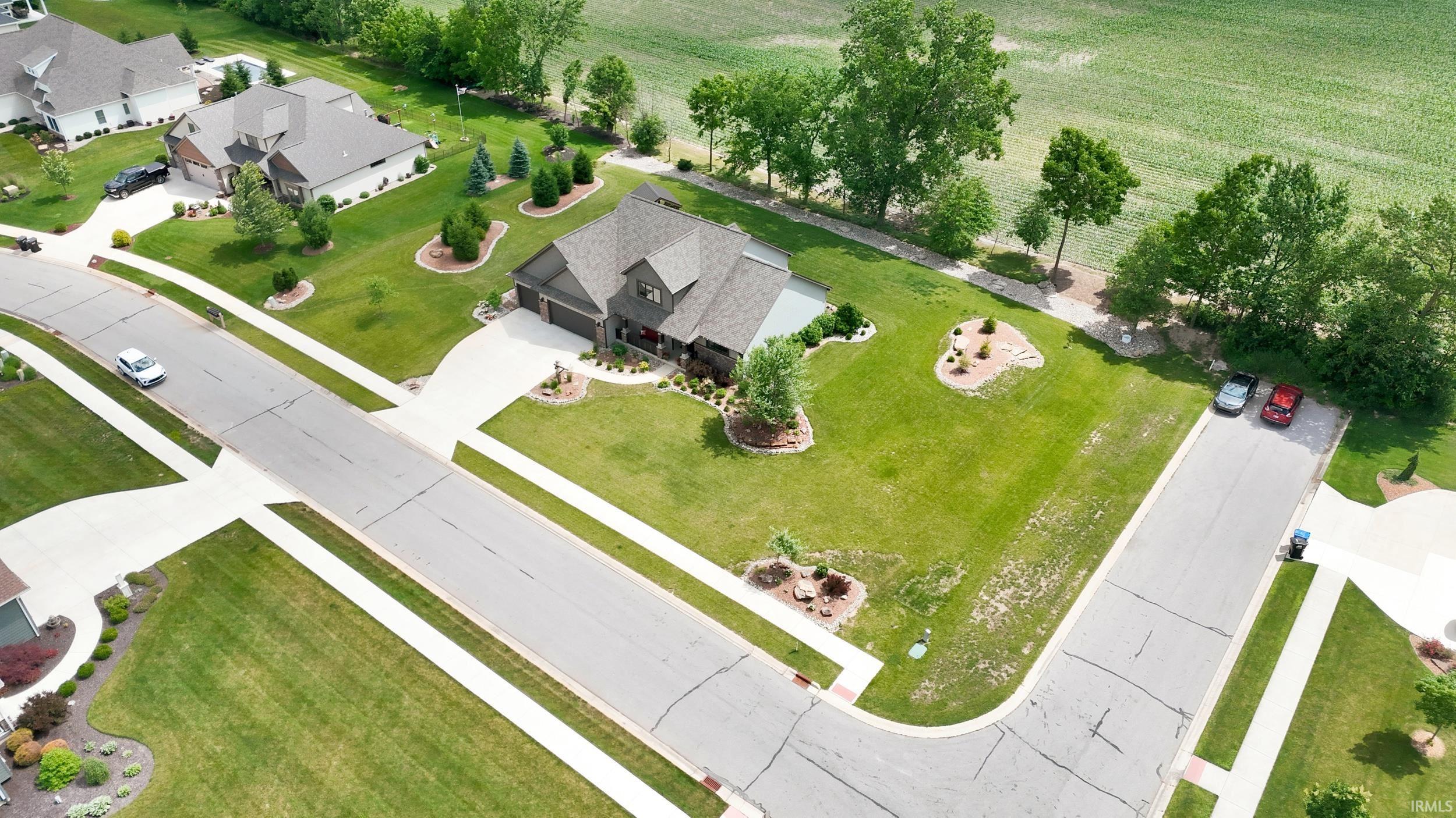 Expansive corner lot featuring mature landscaping and a well-maintained lawn