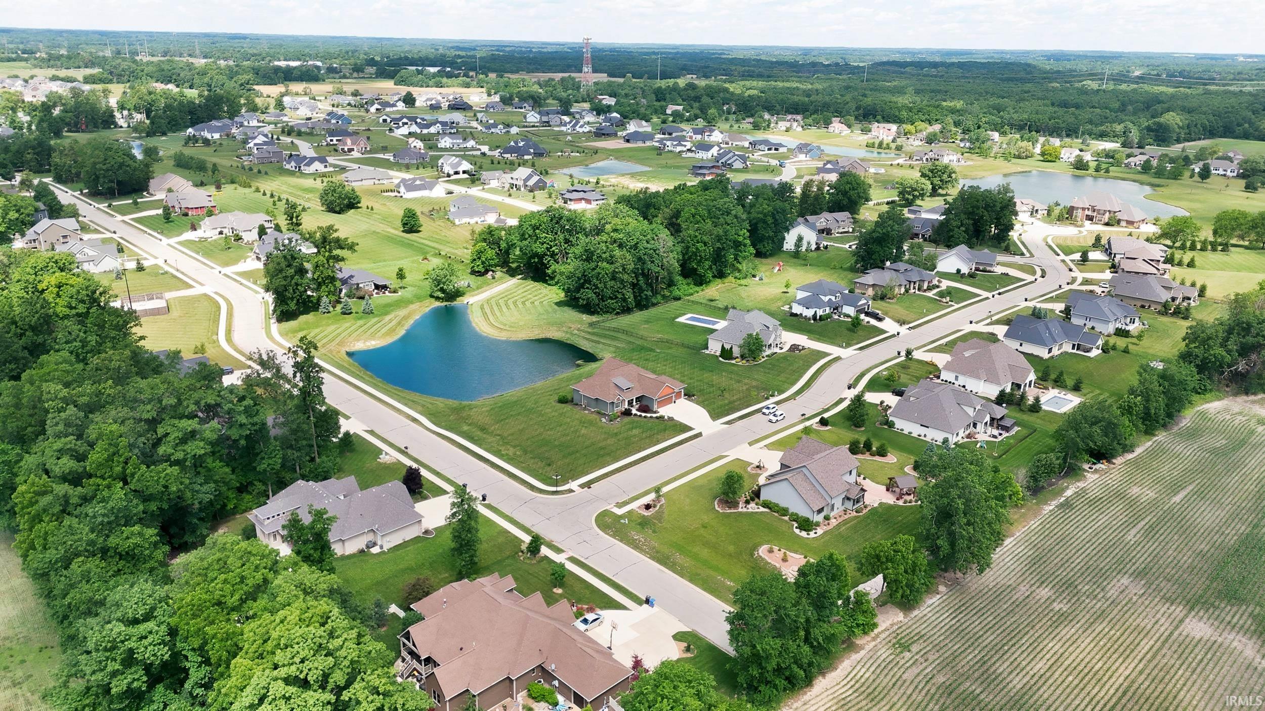Aerial capture of a residential neighborhood featuring established homes, paved streets, and manicured lawns
