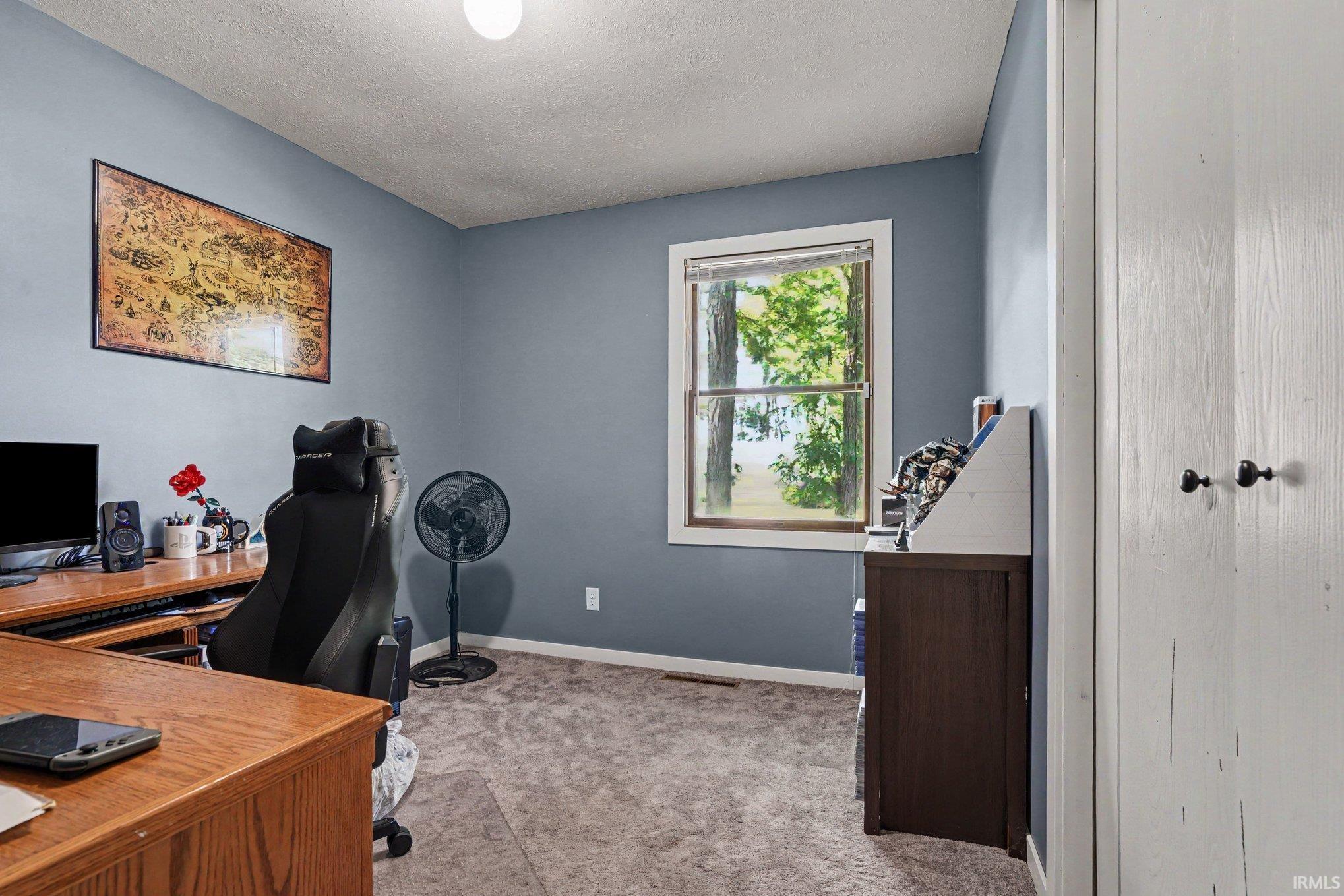 Carpeted room with a single window, light blue wall paint, and a built-in closet with white bifold doors