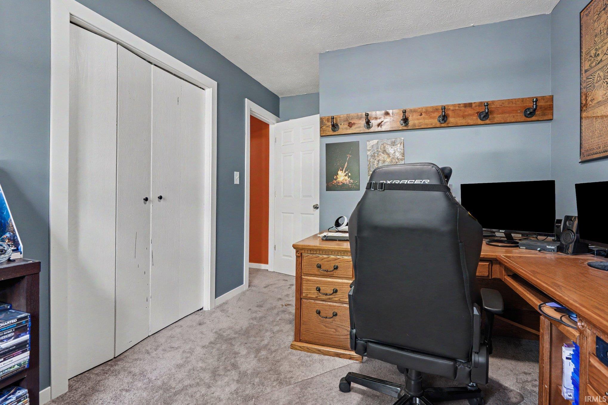 Carpeted room with blue wall paint and white baseboards