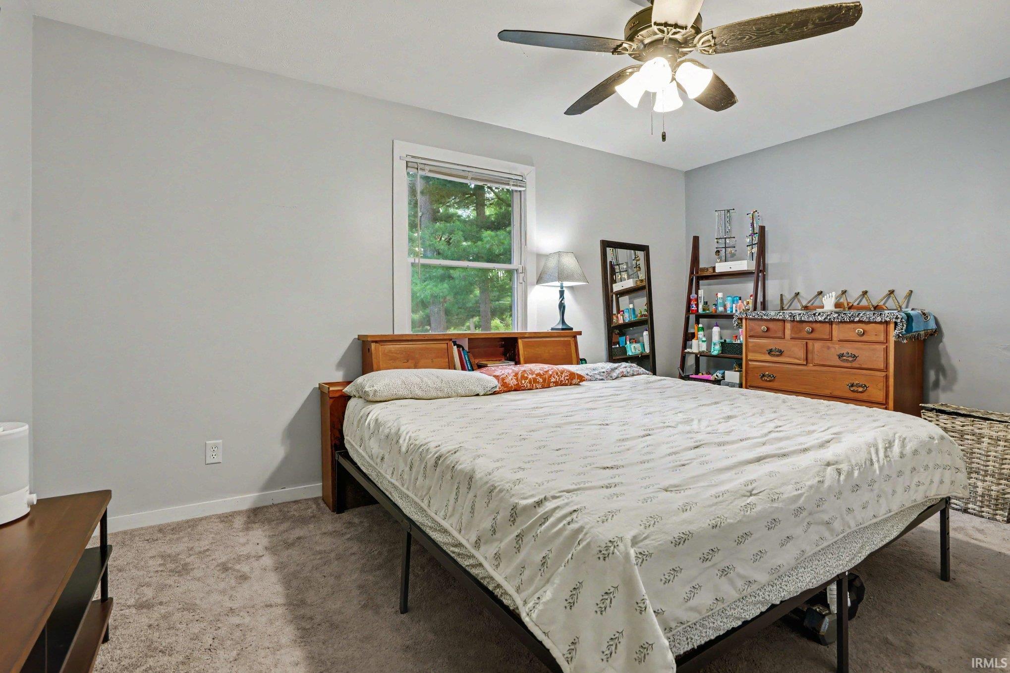 Spacious room with light gray walls and plush gray carpeting