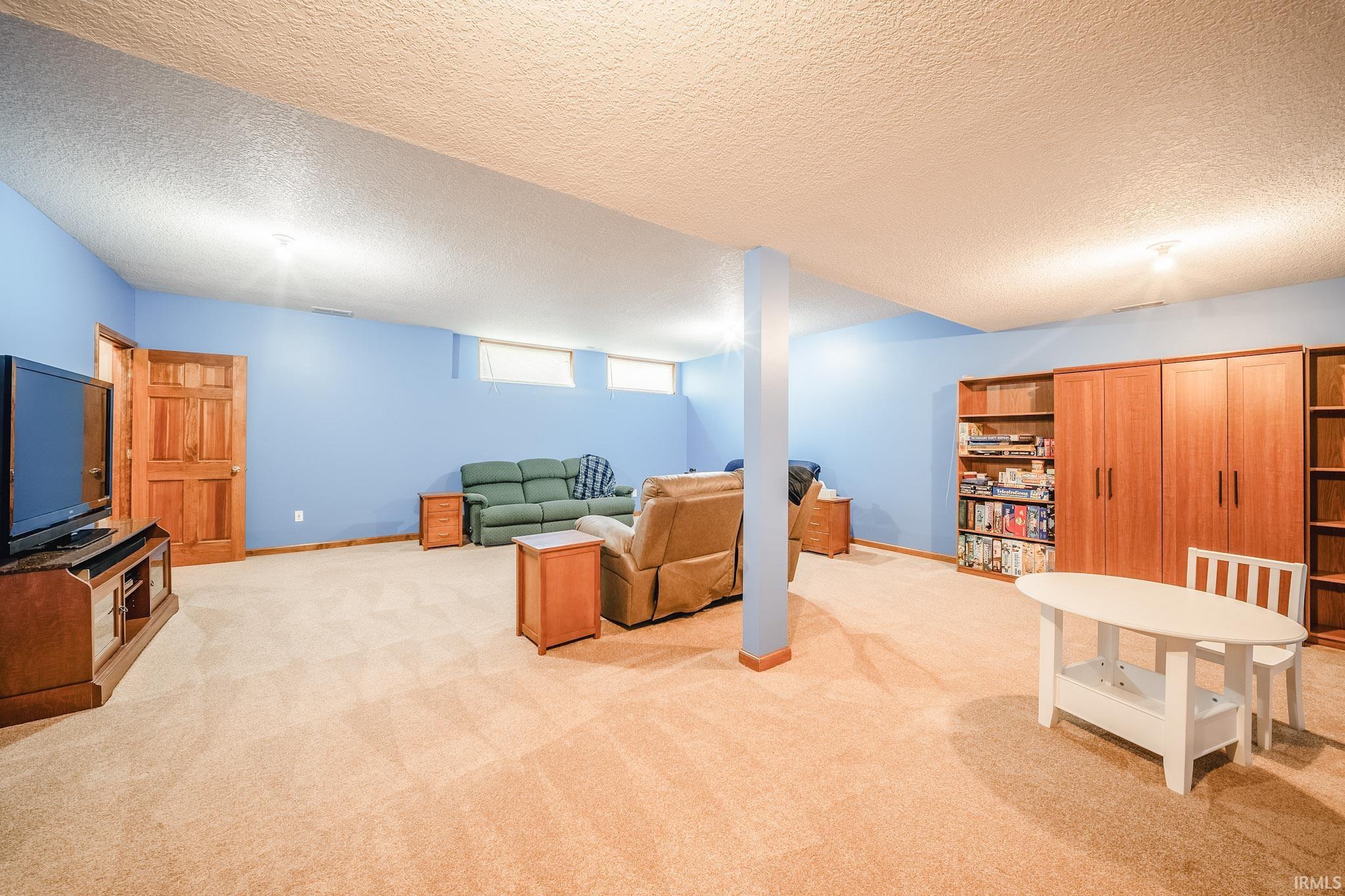 Spacious room featuring carpeting throughout, light blue walls, and a recessed ceiling