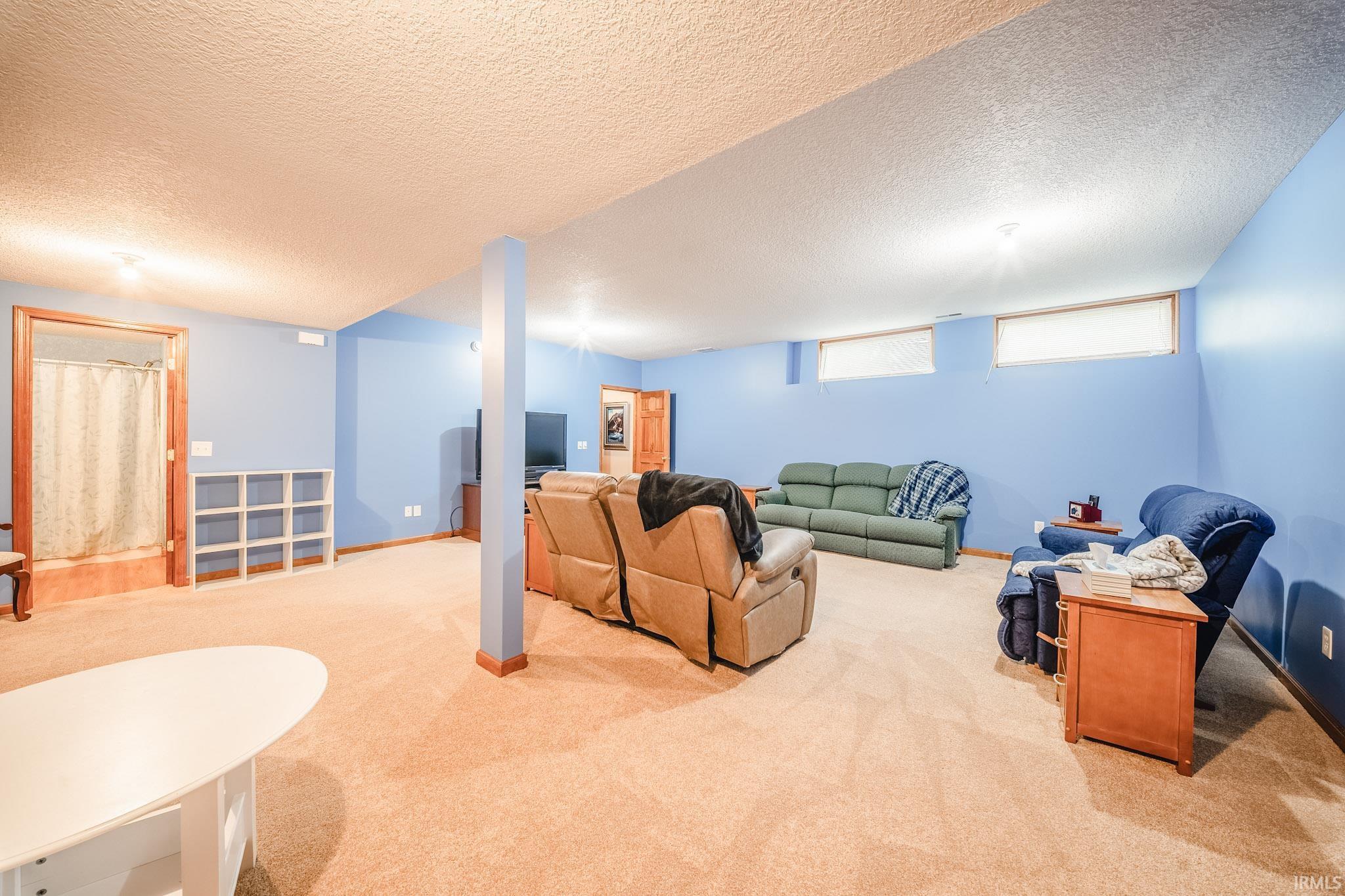 Spacious carpeted room featuring blue walls and multiple windows