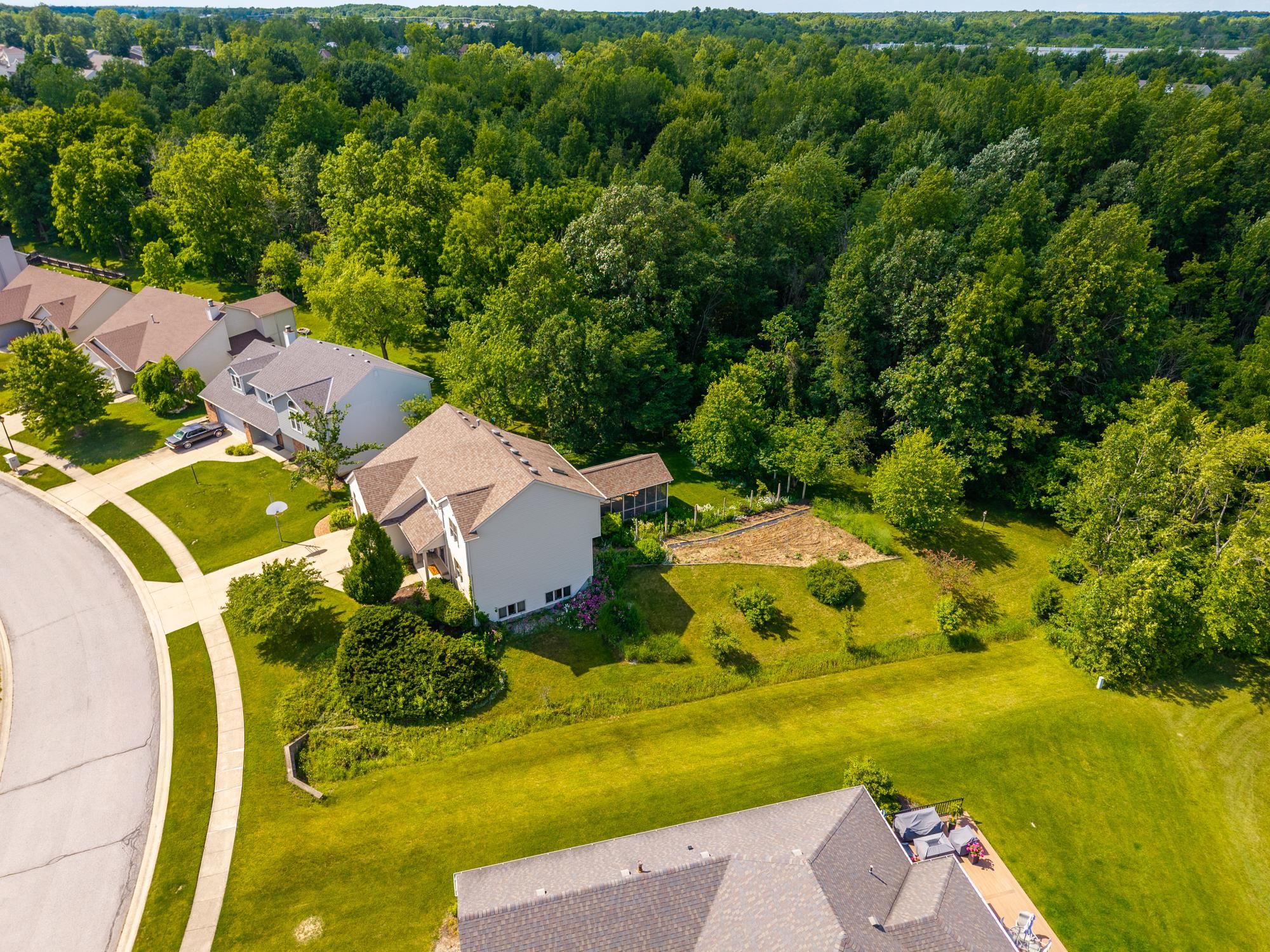 Large residential property featuring a neutral-toned two-story home with a light brown shingle roof