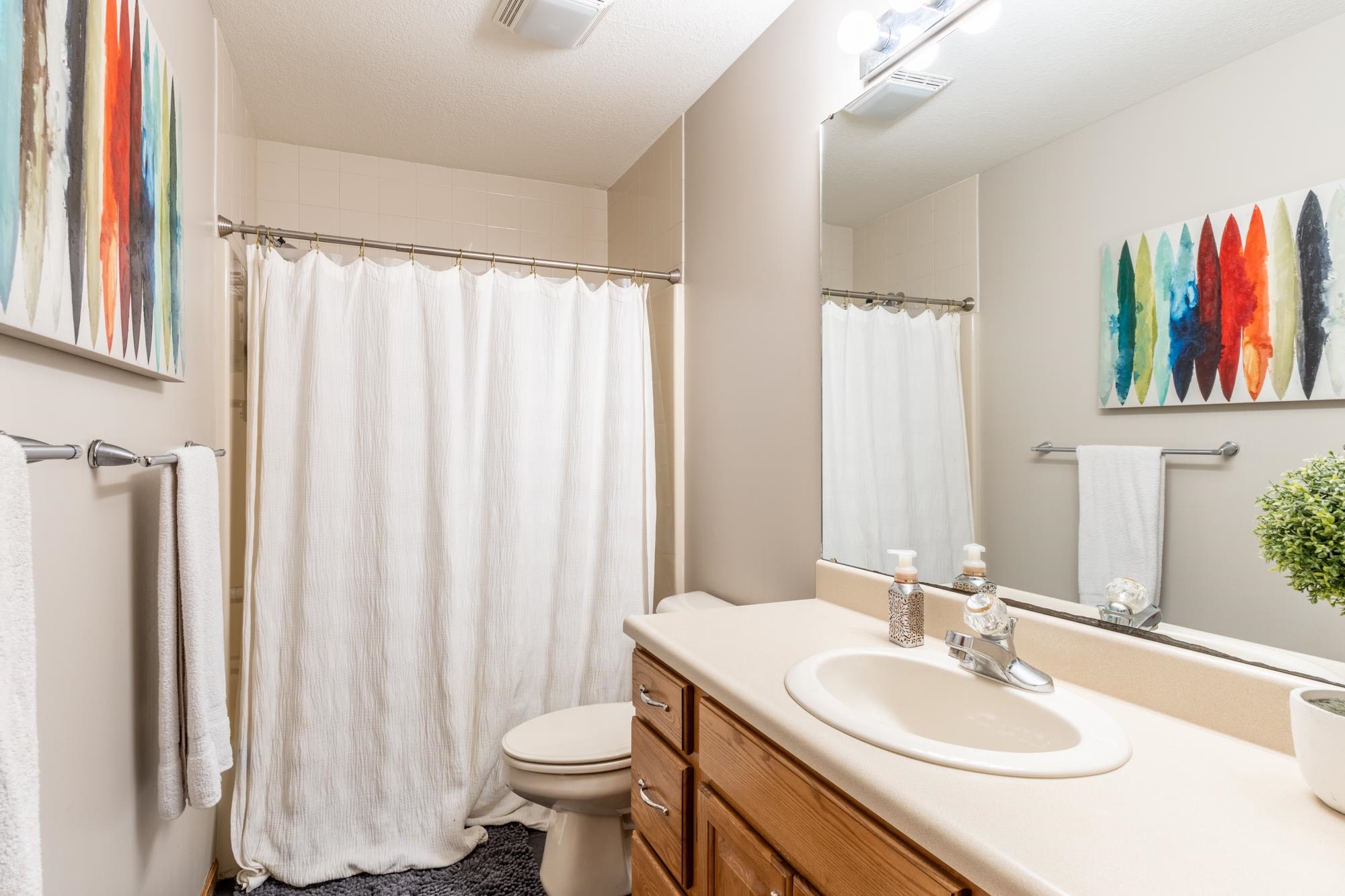 Bathroom featuring a vanity with an integrated sink, chrome faucet, and wood-finish cabinetry
