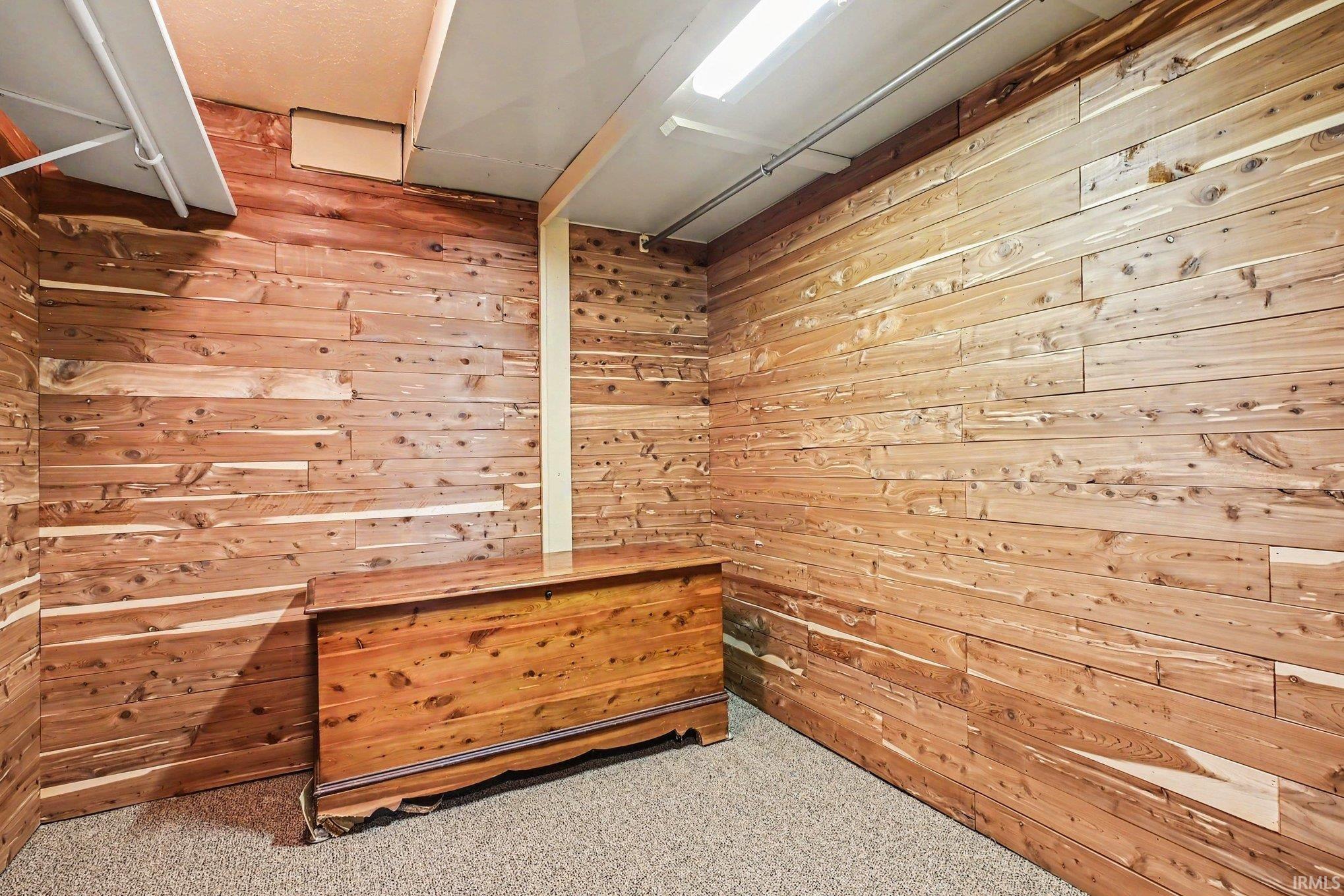 Cedar wood-paneled room with light-colored carpeting