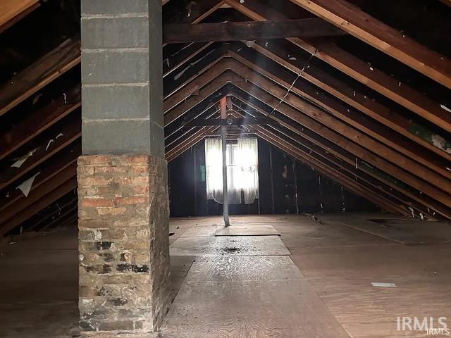 Exposed wooden rafter construction with a brick and concrete block chimney structure