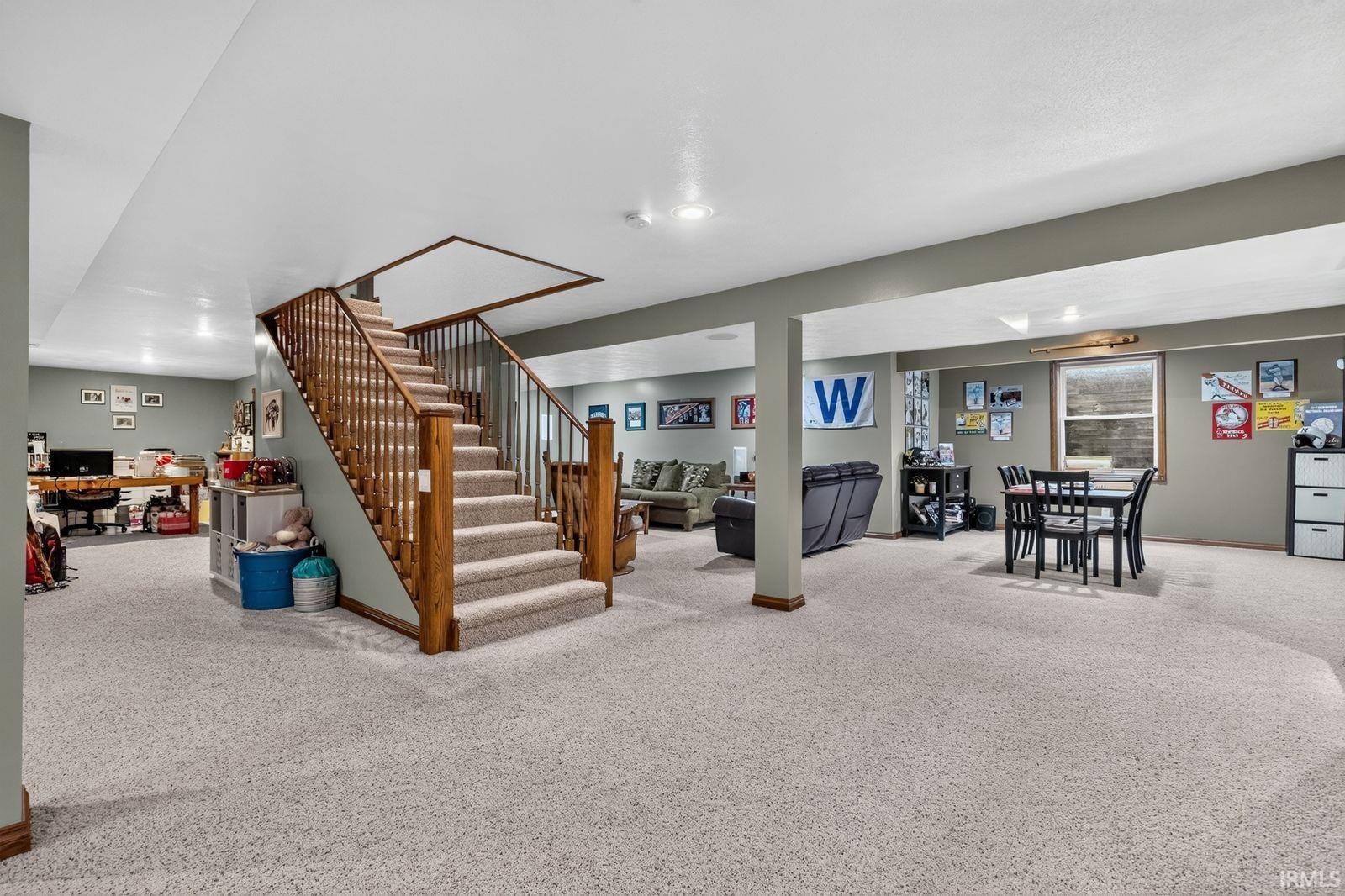 Lower level featuring a staircase with wood railings and carpeting