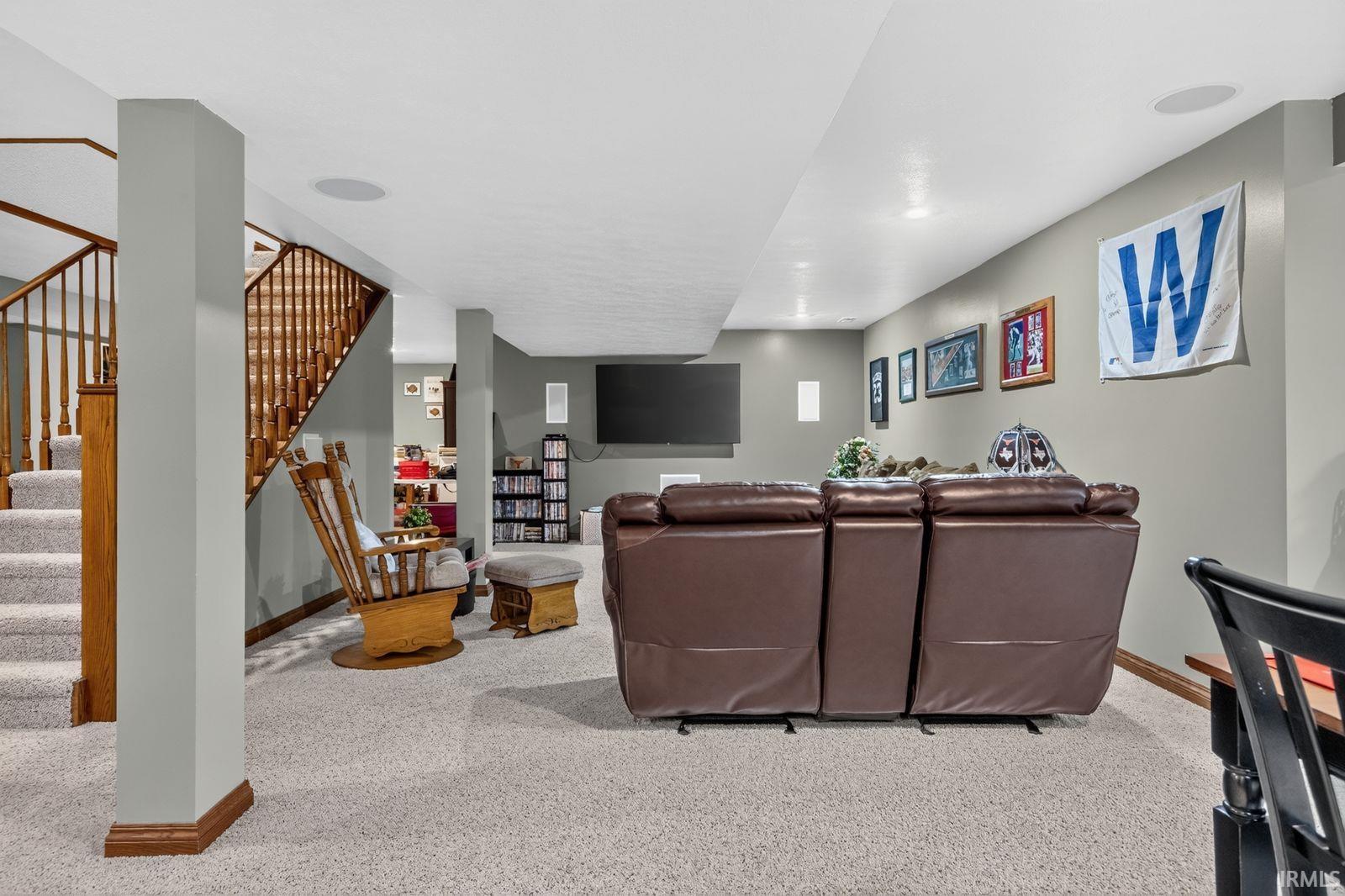 Finished basement with light gray walls and recessed lighting