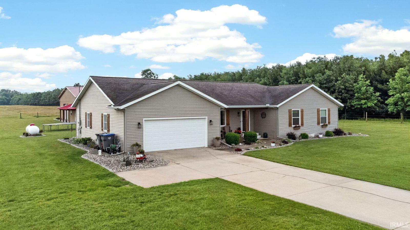 Single-story ranch home featuring light gray siding with white trim and a dark gray shingle roof